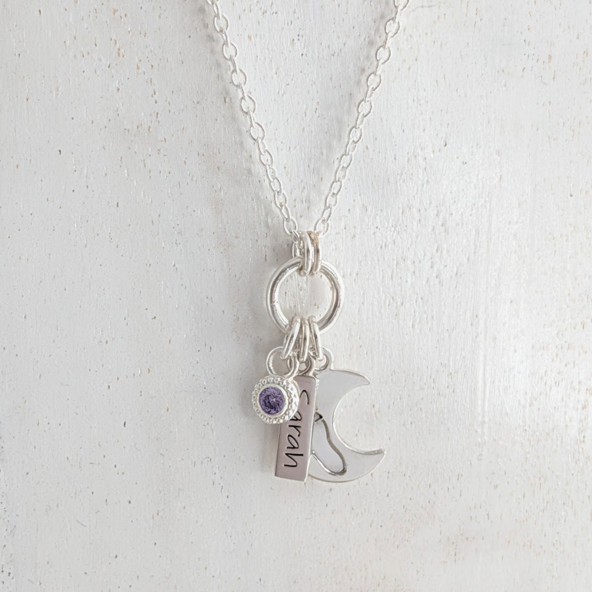 Loved to the moon inspired silver necklace engraved with child's own handprint or footprint and birthstone.