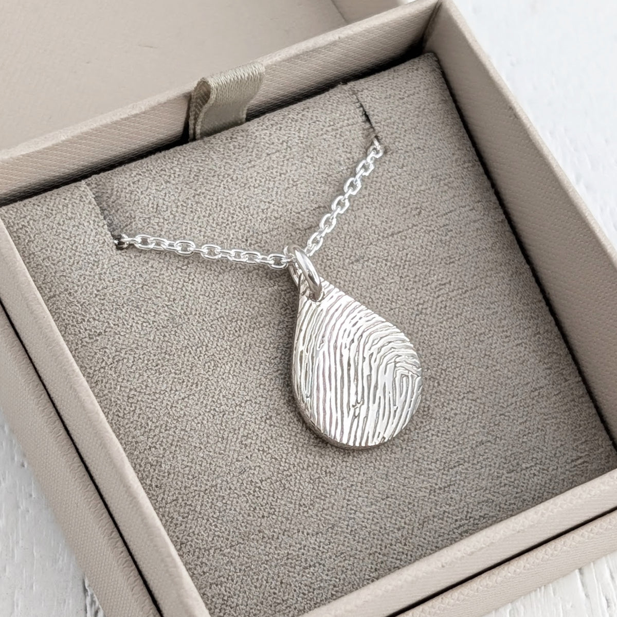 Silver teardrop pendant or necklace engraved with a fingerprint