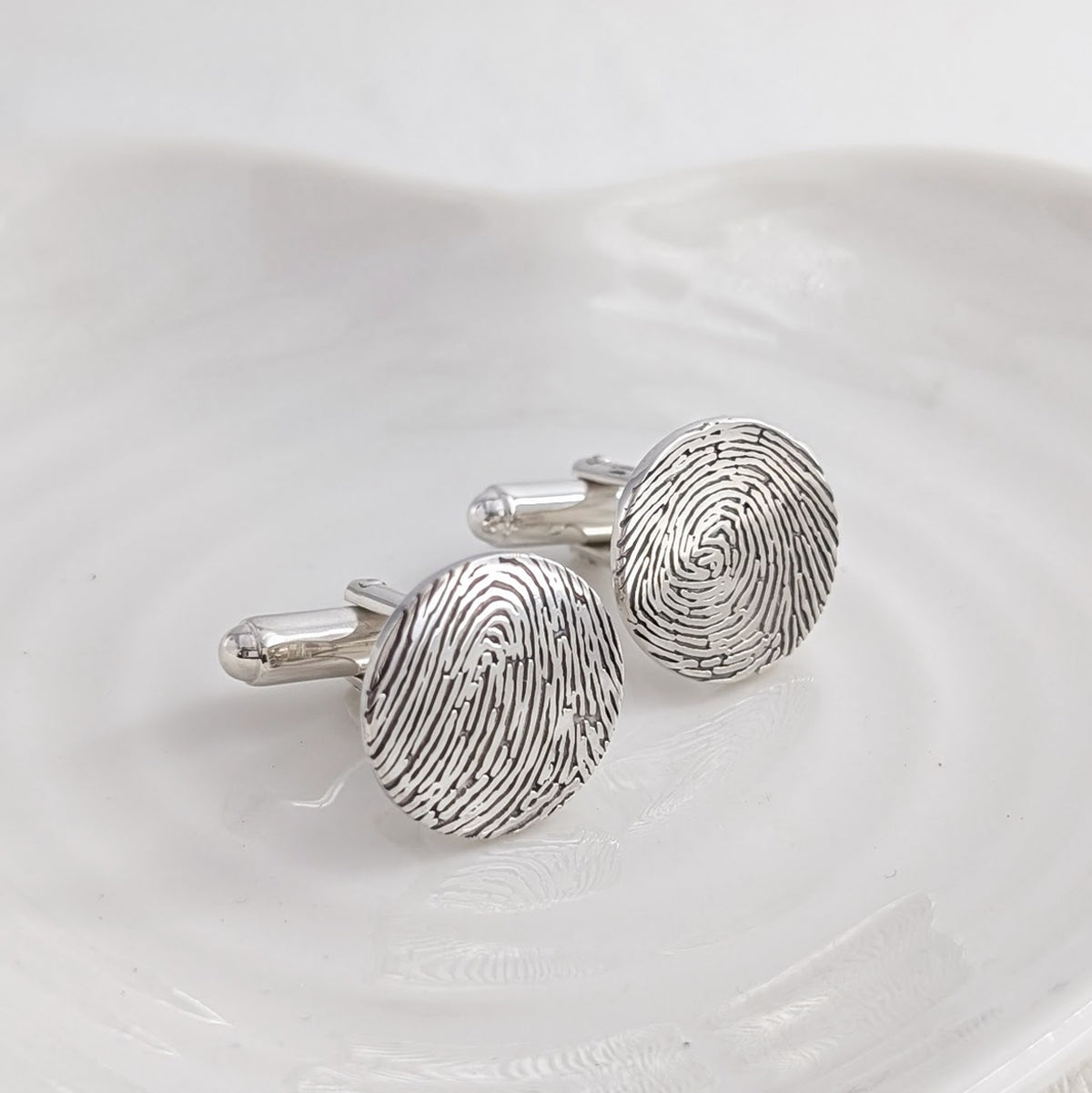 Silver cufflinks engraved with fingerprints