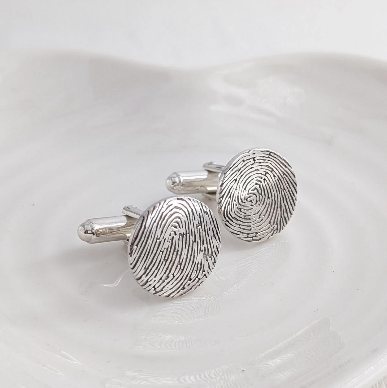 Silver cufflinks engraved with fingerprints