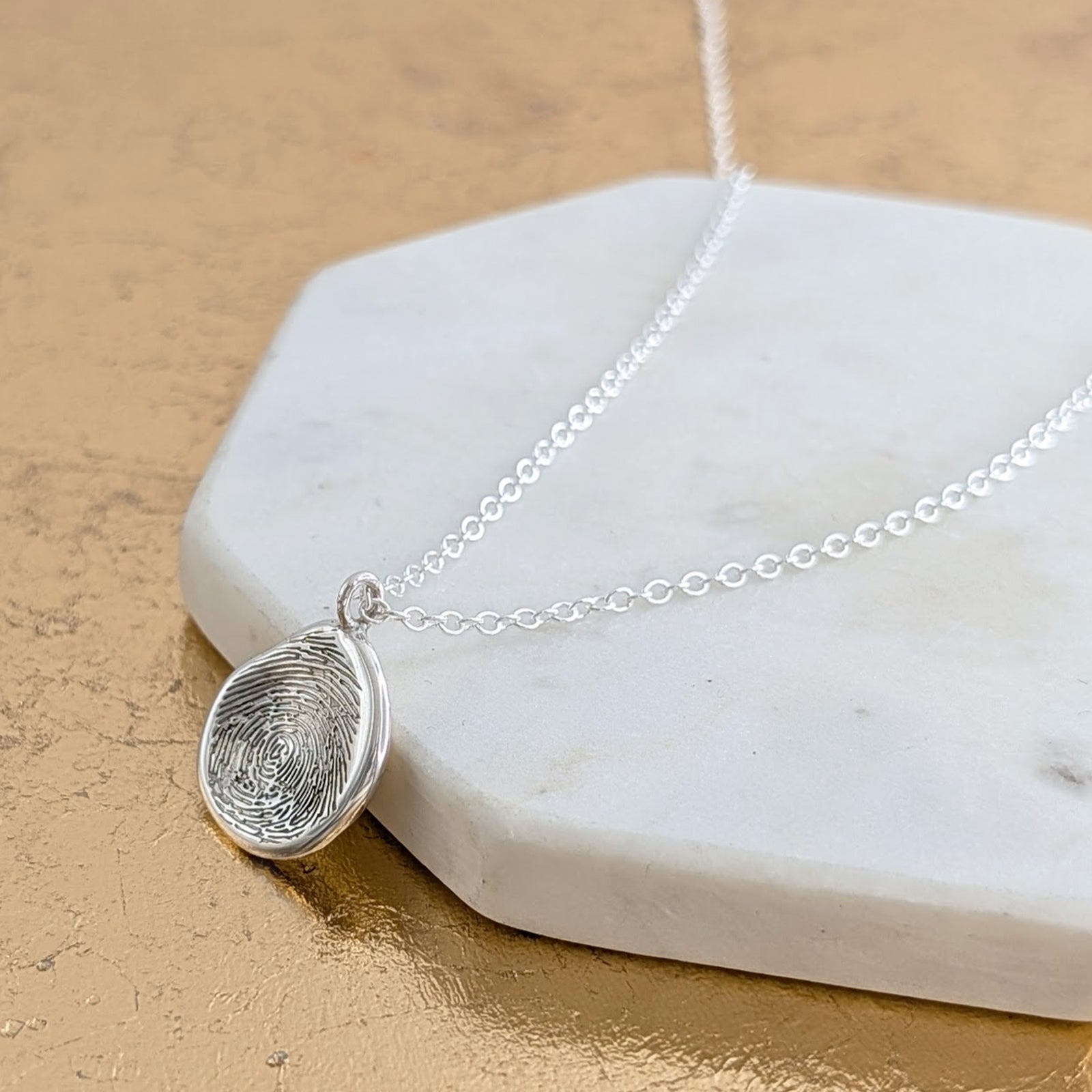 Molten fingerprint pendant in sterling silver engraved with custom fingerprint