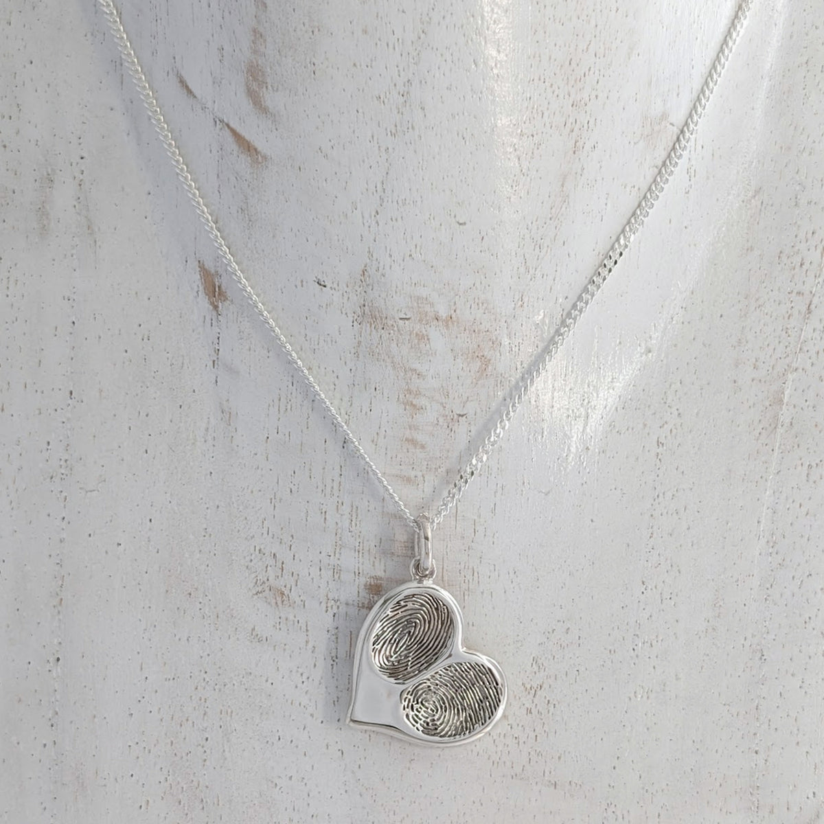 Custom fingerprint heart jewellery handcrafted in the UK, personalised with two genuine fingerprints and available as a sentimental memorial necklace or family keepsake.