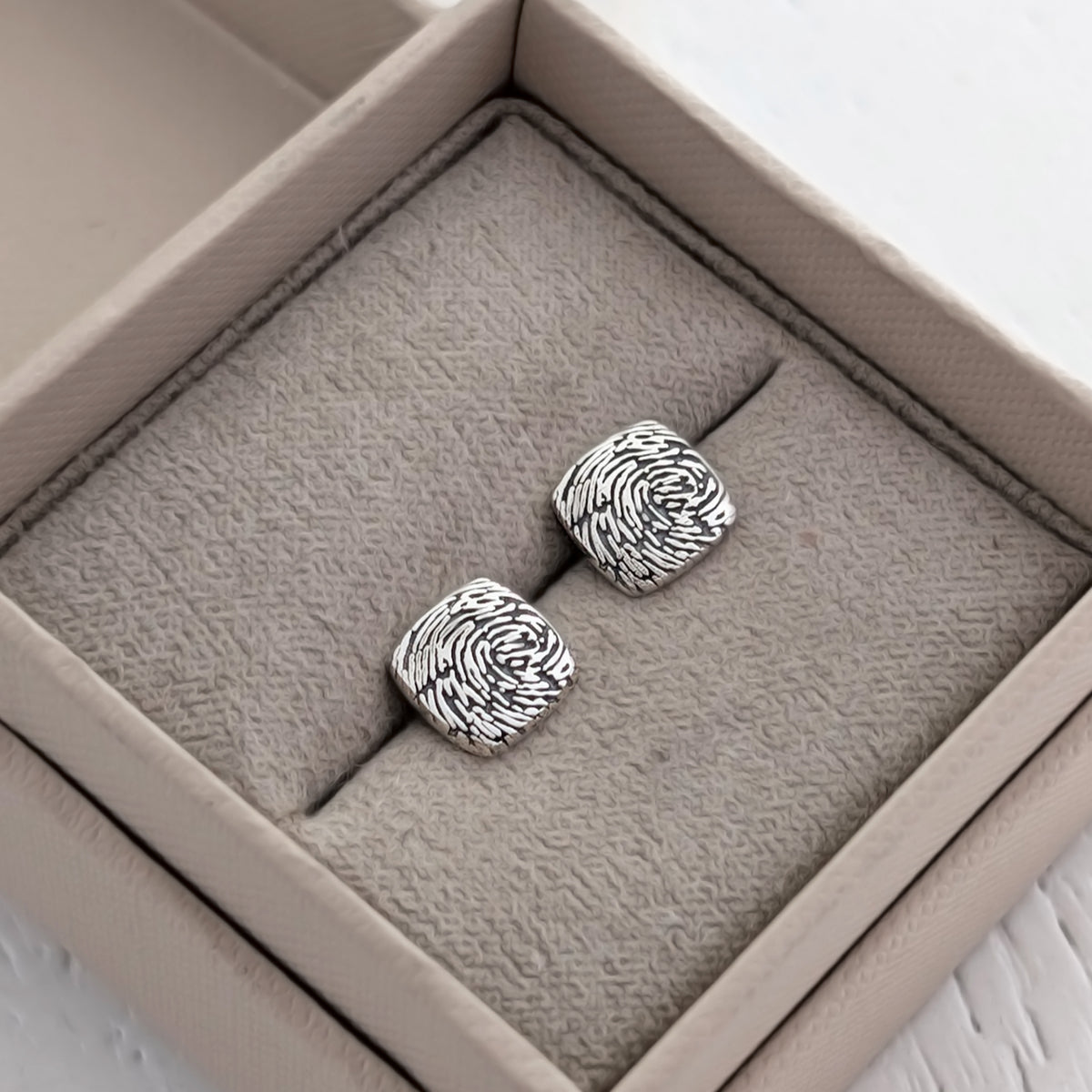 Square cushion fingerprint stud earrings, individually handmade in silver or gold and engraved with a real fingerprint to create a meaningful keepsake.