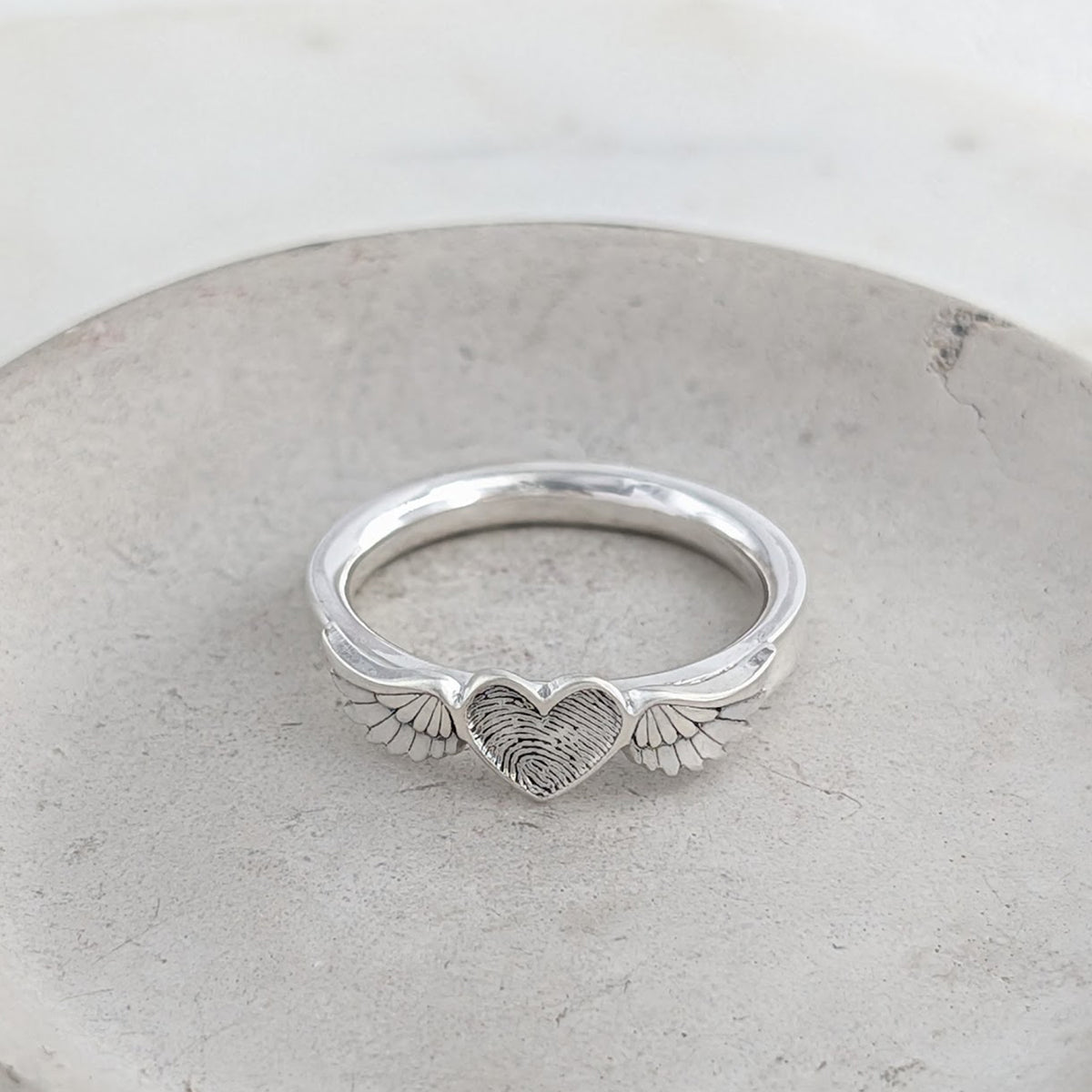 Sterling silver fingerprint memorial ring featuring an engraved heart framed by detailed angel wings.
