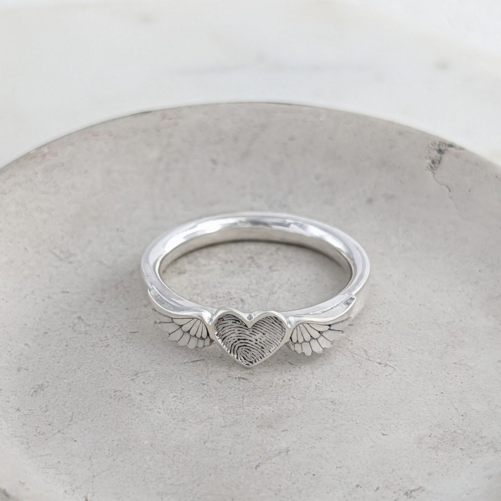 Sterling silver fingerprint memorial ring featuring an engraved heart framed by detailed angel wings.