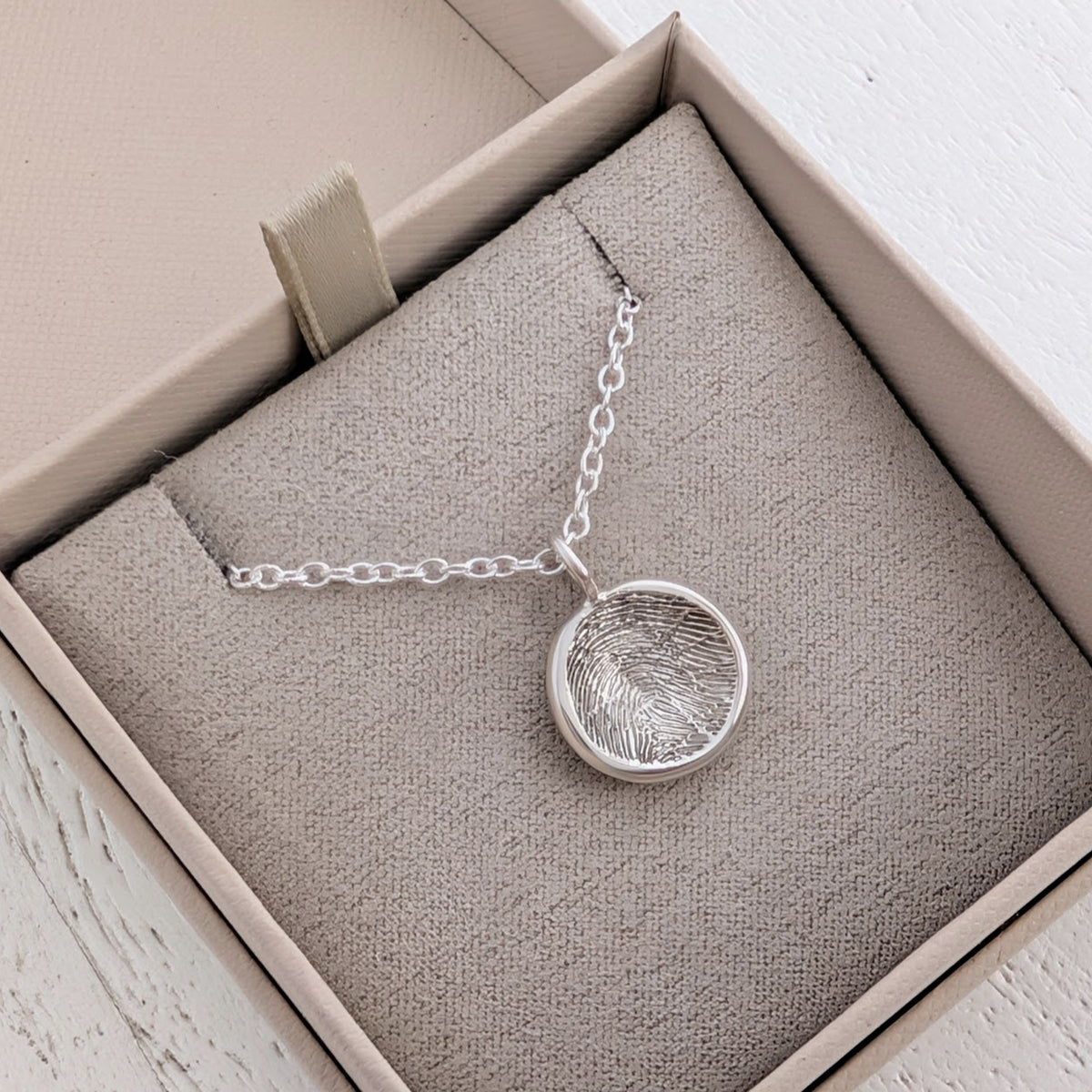 Handmade Circular Fingerprint Charm crafted from silver or gold and personalised with a genuine fingerprint. A meaningful memorial jewellery piece and thoughtful keepsake gift for family, friends or loved ones.