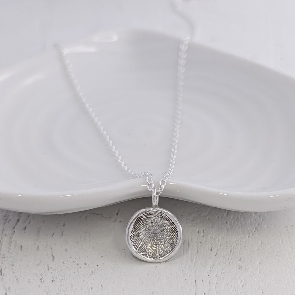 Soft Circle Fingerprint Charm handcrafted in sterling silver or solid gold. Featuring a real fingerprint engraved within a smooth circular design, creating a timeless keepsake charm filled with meaning and connection.