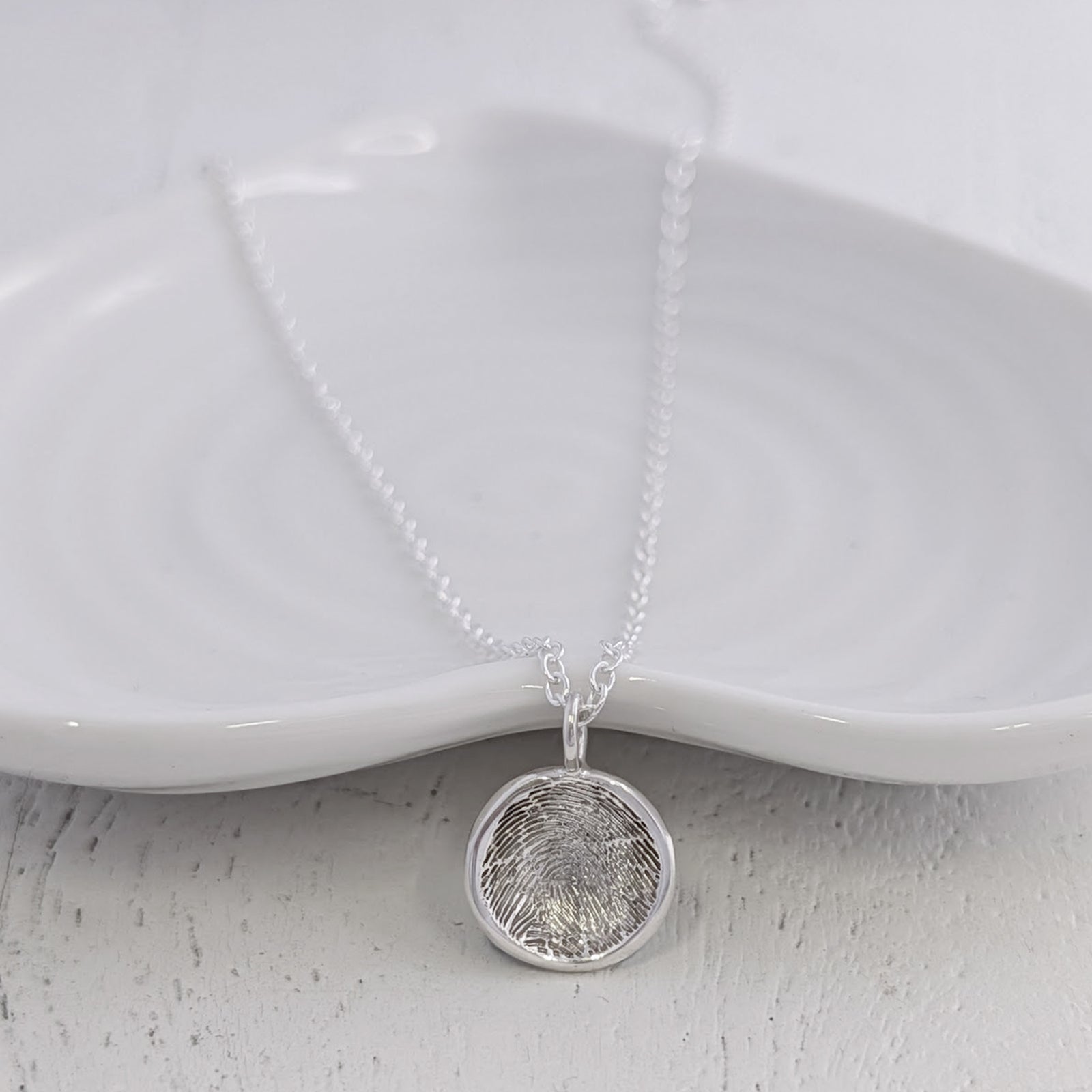Soft Circle Fingerprint Charm handcrafted in sterling silver or solid gold. Featuring a real fingerprint engraved within a smooth circular design, creating a timeless keepsake charm filled with meaning and connection.