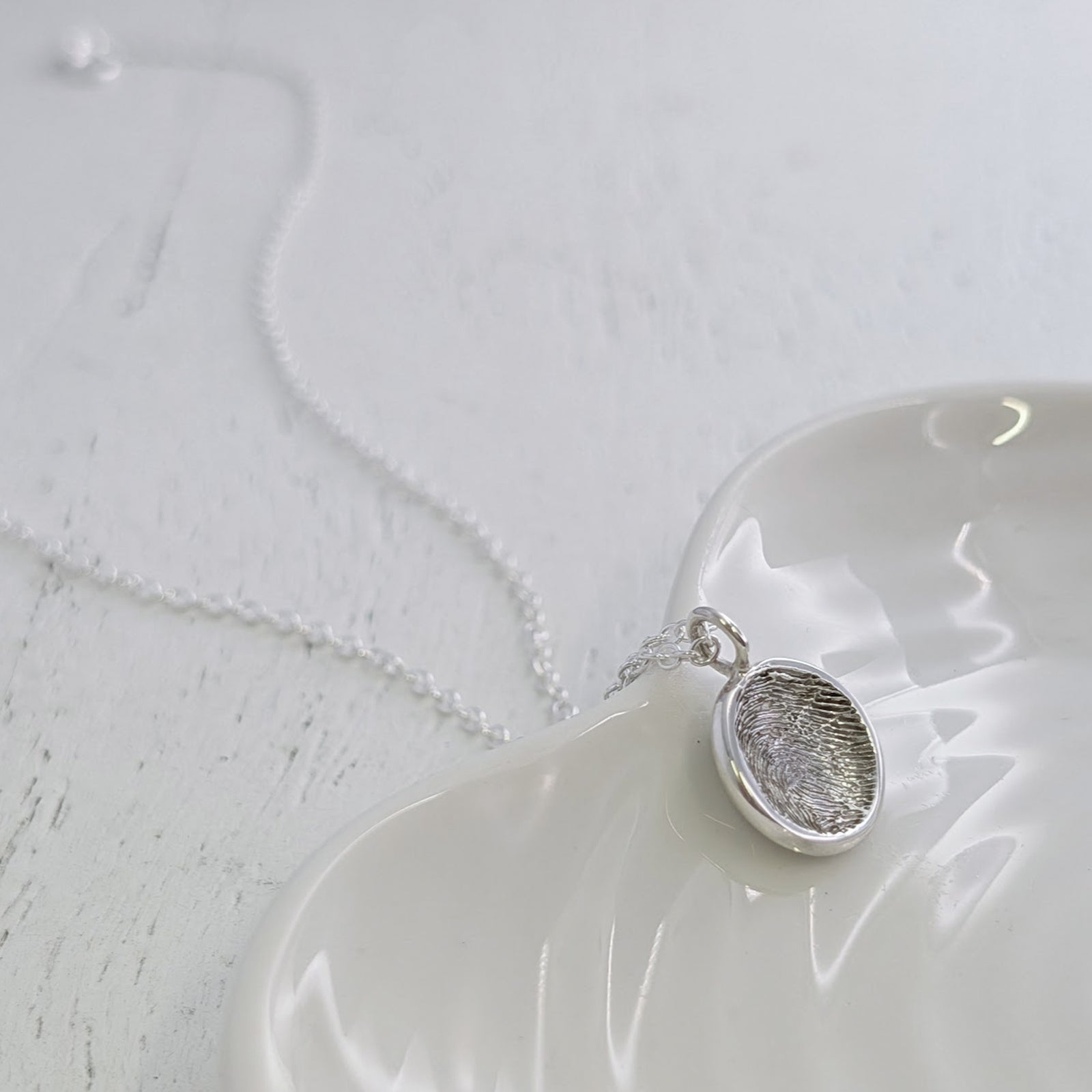 Round Fingerprint Charm personalised with a real fingerprint and handcrafted in sterling silver or gold. This elegant keepsake jewellery design captures every loop and whorl, creating a lasting reminder of someone special.