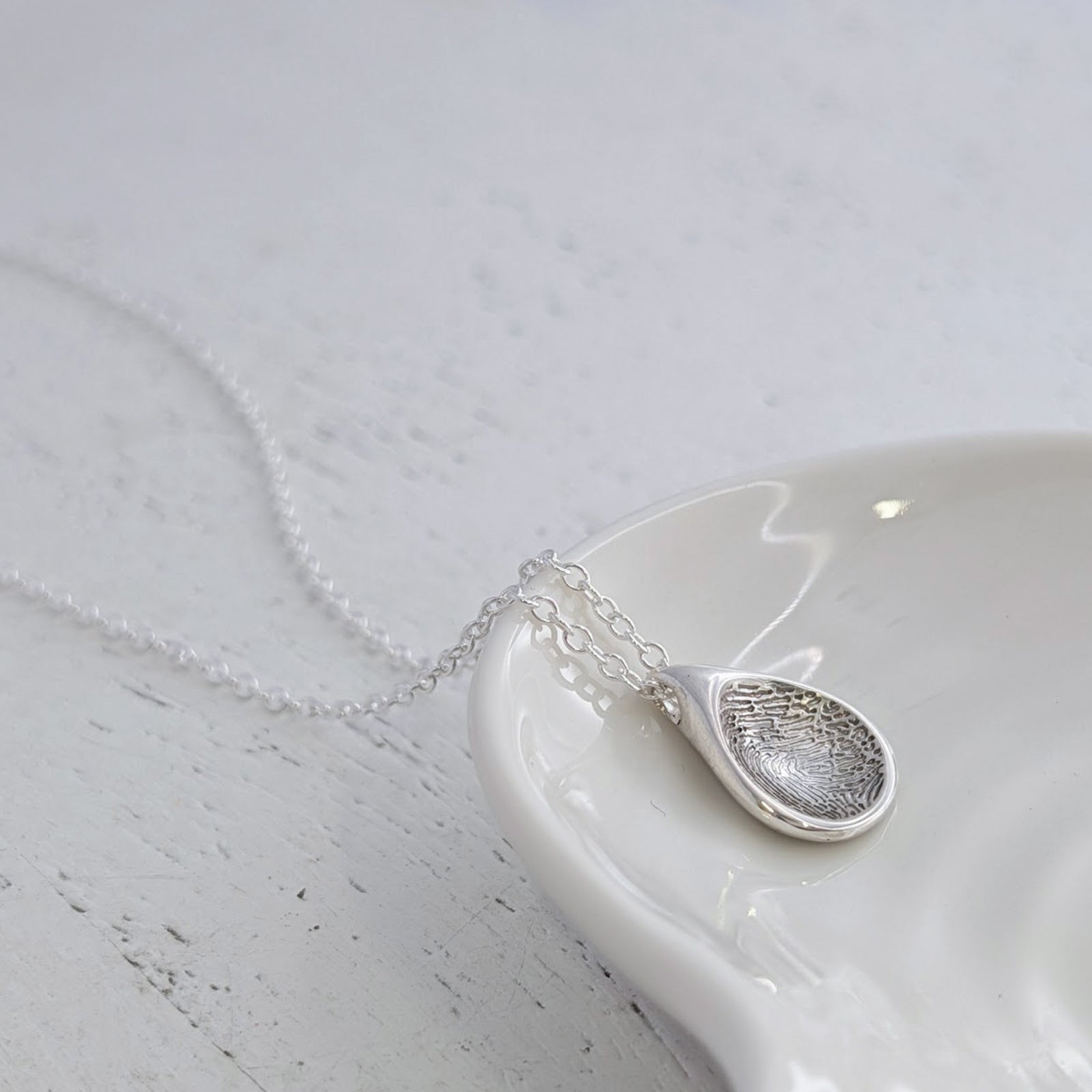 Bespoke Soft Droplet Fingerprint Charm crafted from sterling silver or solid gold. This elegant personalised fingerprint jewellery captures every loop and whorl, creating a lasting connection to someone special.