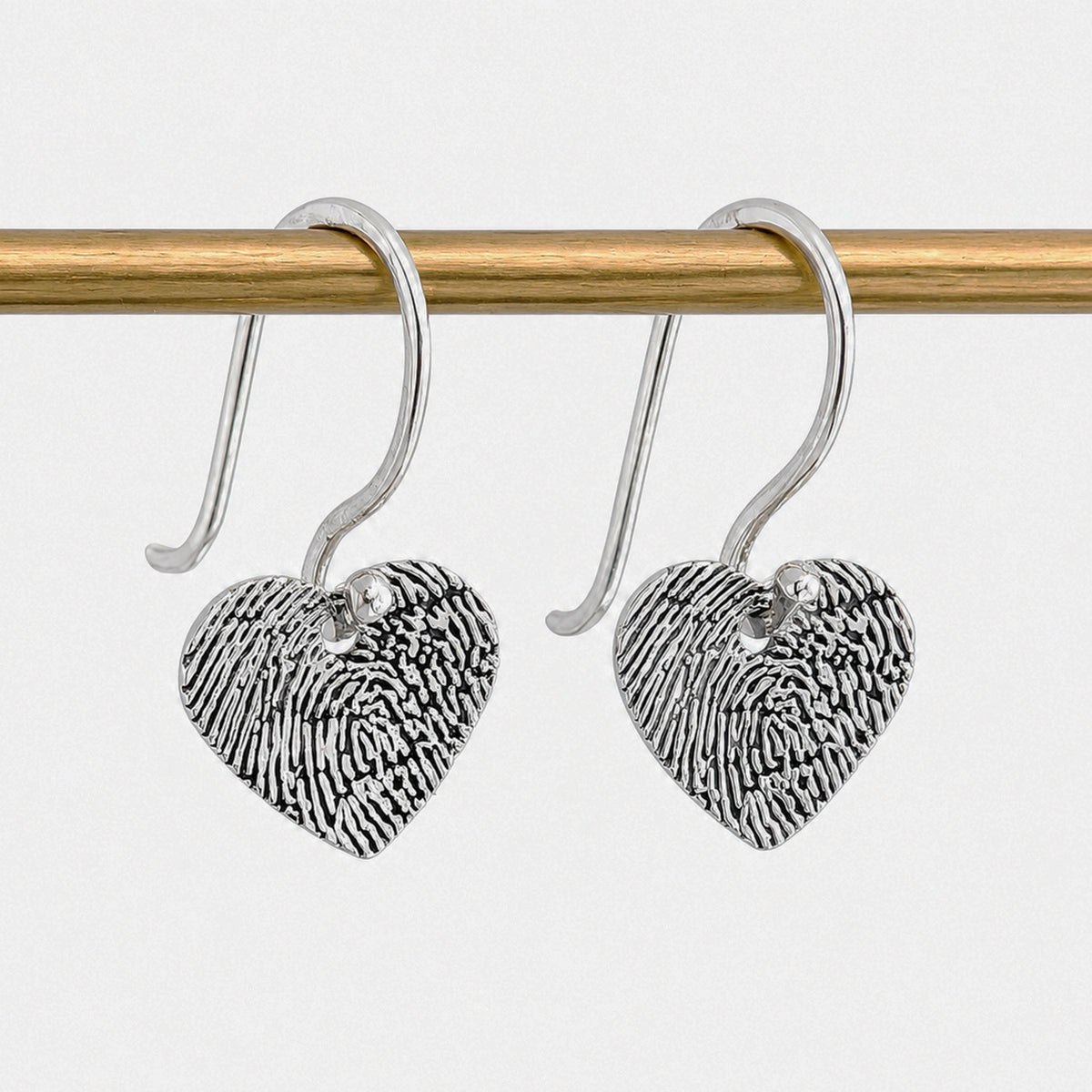 Fingerprint Heart Drop Earrings in Silver or Gold – Beautiful personalised heart dangle earrings engraved with a real fingerprint. Handmade in sterling silver or solid gold as a meaningful keepsake jewellery gift.