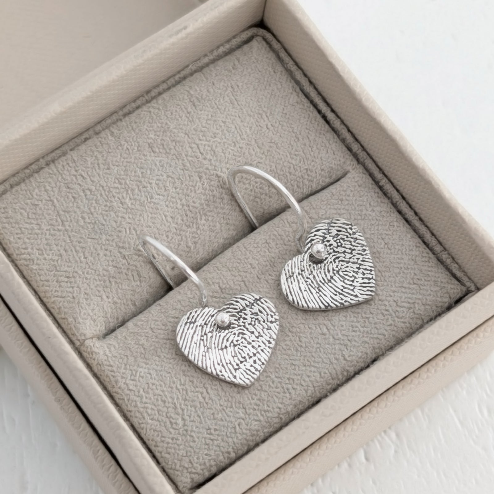 Handmade Fingerprint Heart Dangle Earrings – Elegant memorial and keepsake earrings engraved with a genuine fingerprint. Crafted in sterling silver or solid gold with classic ear hooks and a timeless heart design.