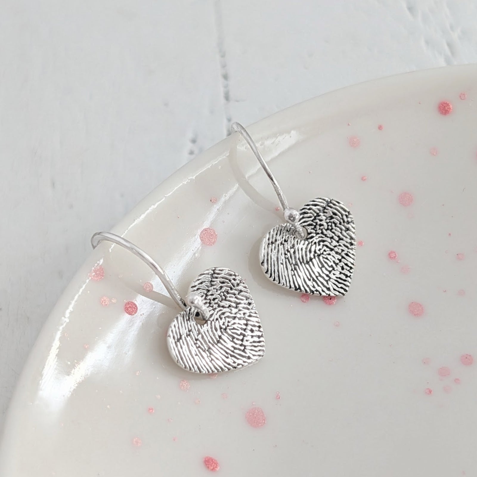 Engraved Fingerprint Heart Jewellery Earrings – Personalised heart drop earrings showcasing the unique ridges and details of a real fingerprint. Handmade in Shropshire from sterling silver or solid gold for a lasting sentimental gift.
