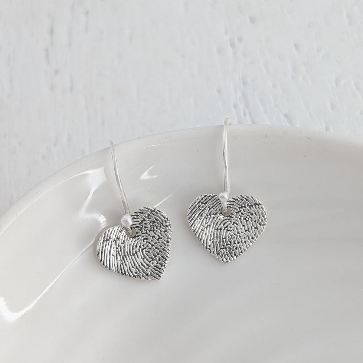 Personalised Fingerprint Heart Earrings – Delicate heart-shaped drop earrings featuring your loved one's unique fingerprint captured in intricate detail. Handcrafted to order in sterling silver or gold.