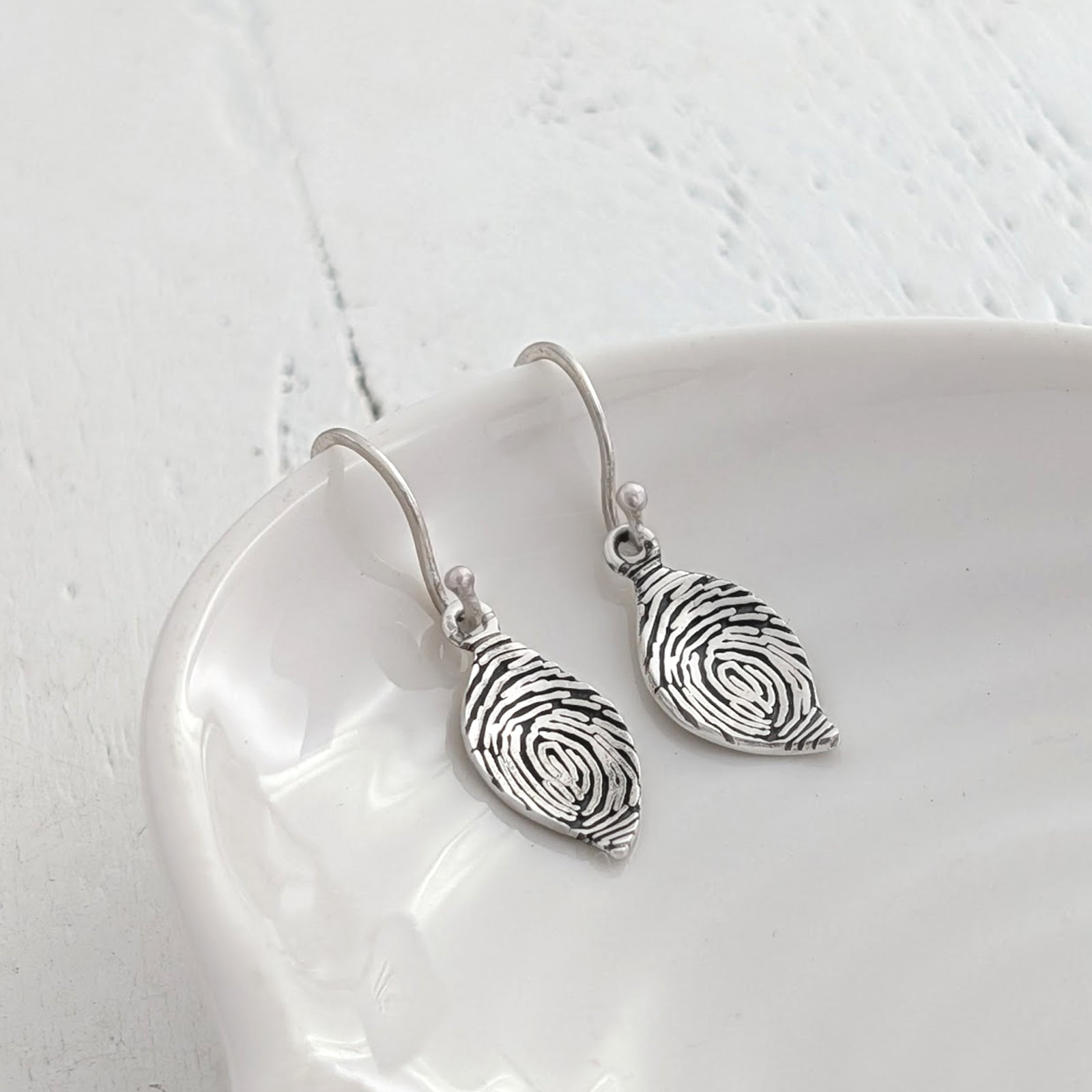 Fingerprint Leaf Dangle Earrings in Silver or Gold – Elegant personalised leaf drop earrings engraved with a real fingerprint. Handmade in sterling silver or solid gold, creating a meaningful keepsake jewellery gift.