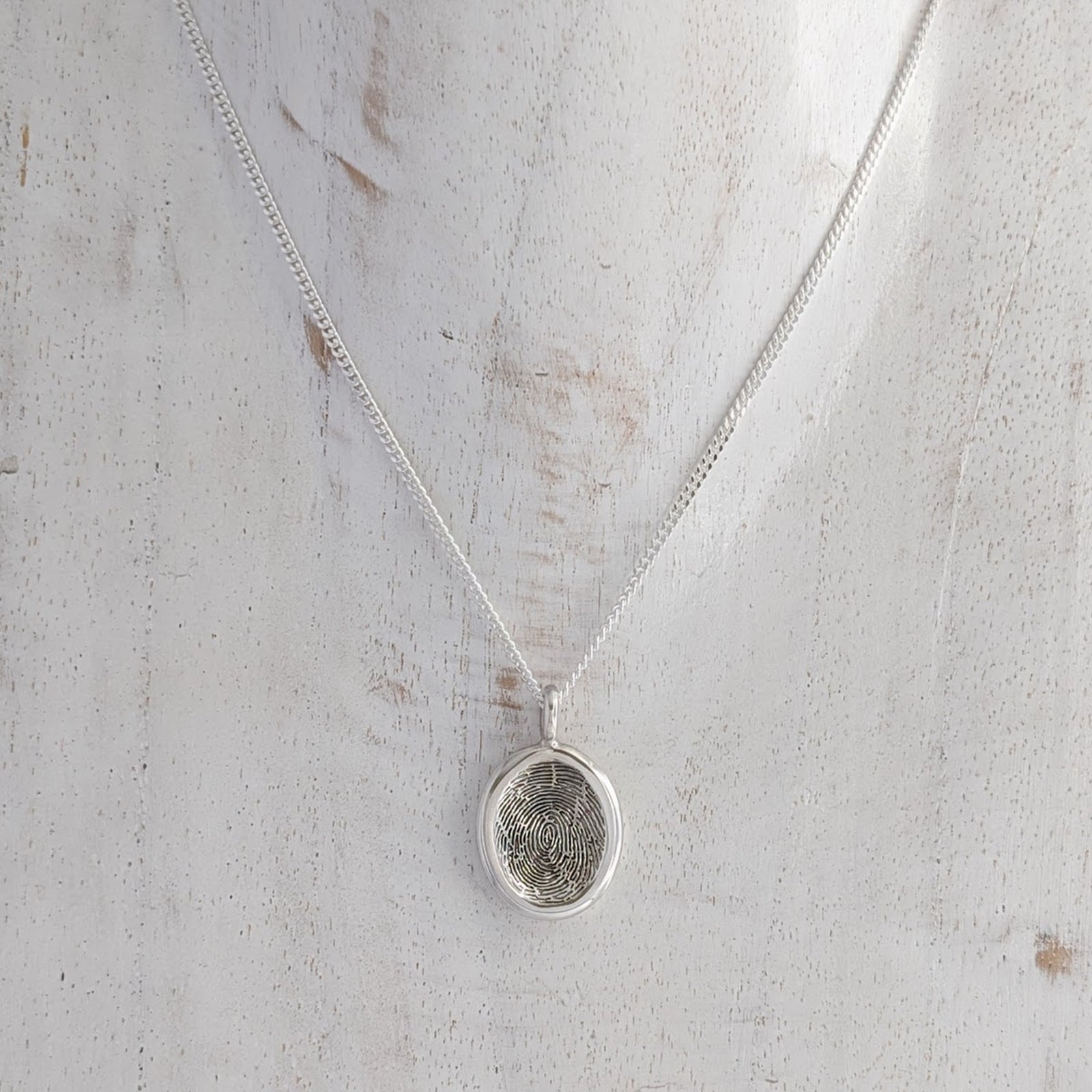 Silver fingerprint necklace on a silver chain