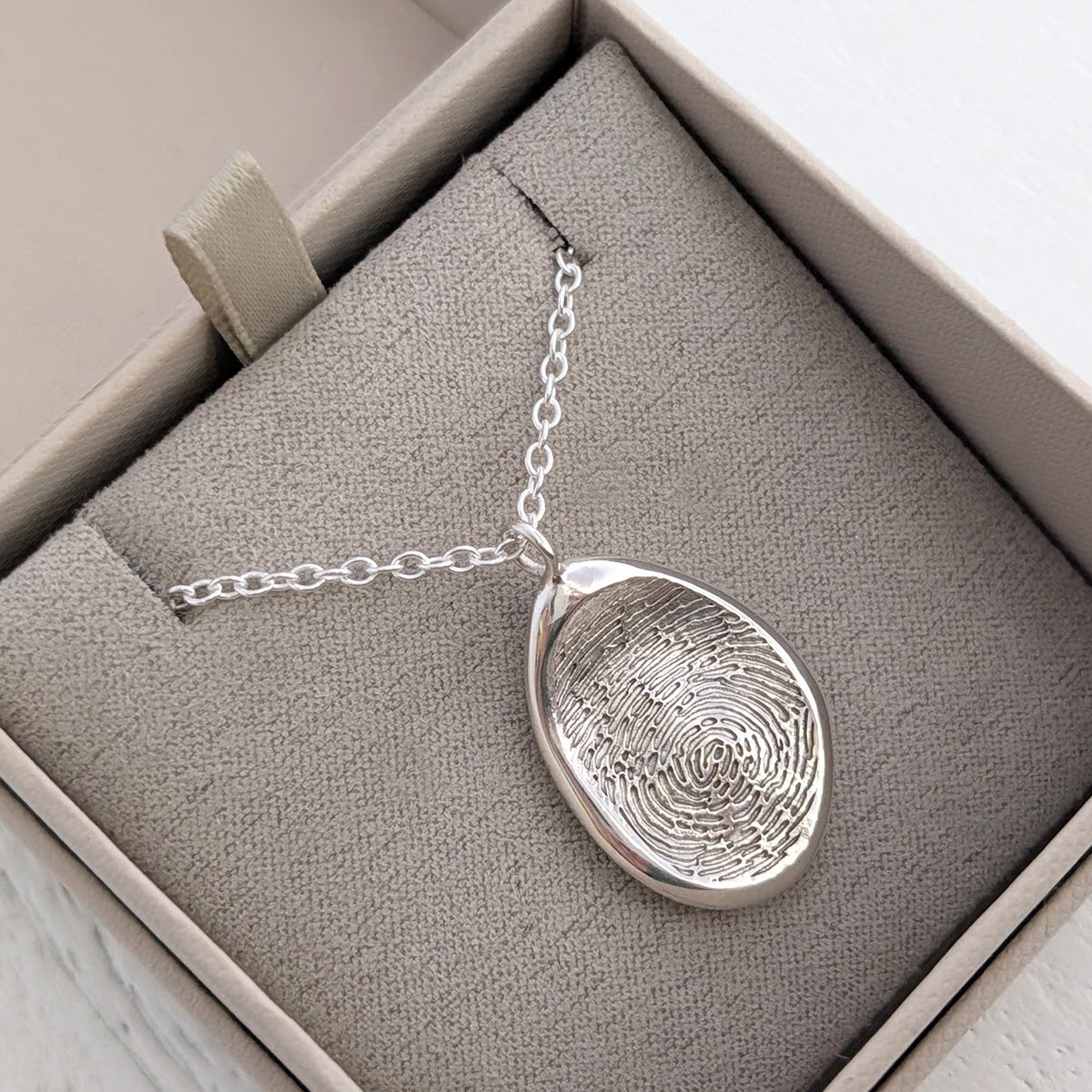 Handmade Organic Fingerprint Pendant in silver or gold, individually crafted using your own fingerprint. A unique memorial jewellery piece and sentimental keepsake necklace designed to hold precious memories close.