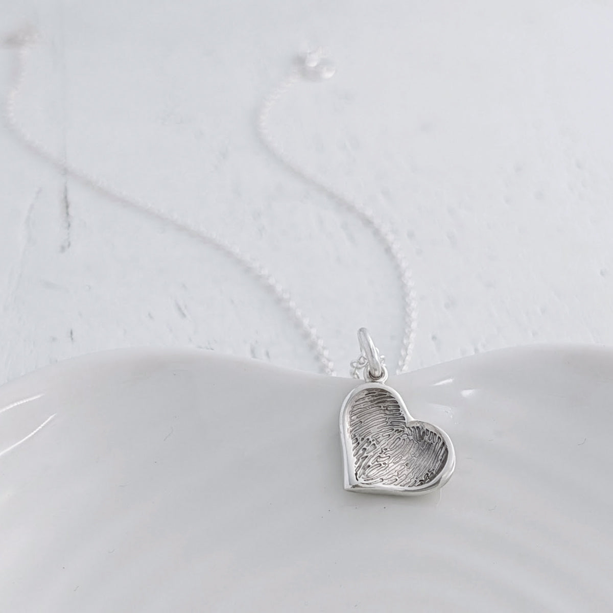 Personalised Soft Heart Fingerprint Charm available in sterling silver, 9ct gold or 18ct gold. Handmade to order and engraved with a genuine fingerprint, preserving the unique detail of someone special forever.