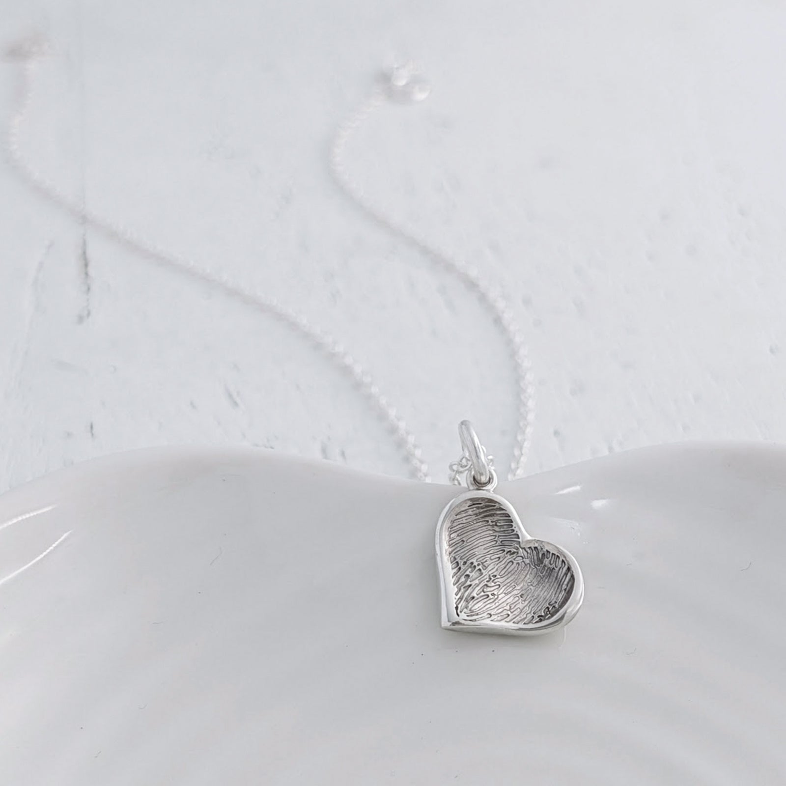 Personalised Soft Heart Fingerprint Charm available in sterling silver, 9ct gold or 18ct gold. Handmade to order and engraved with a genuine fingerprint, preserving the unique detail of someone special forever.