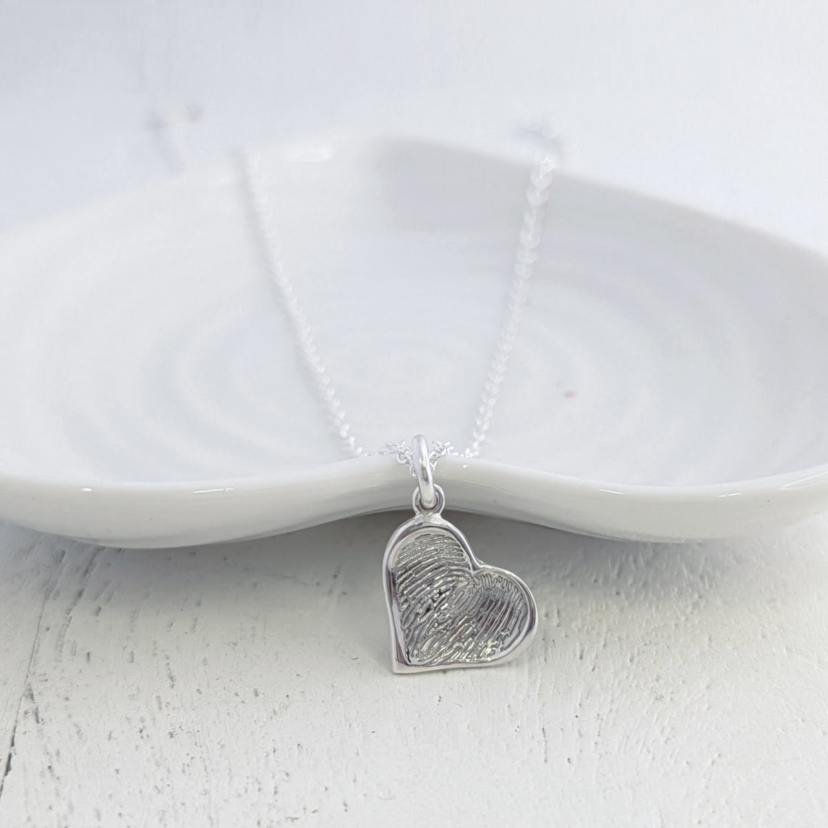 Soft Heart Fingerprint Charm handcrafted in sterling silver or solid gold. Personalised with a real fingerprint and framed within a softly sculpted heart, creating a meaningful keepsake jewellery gift.