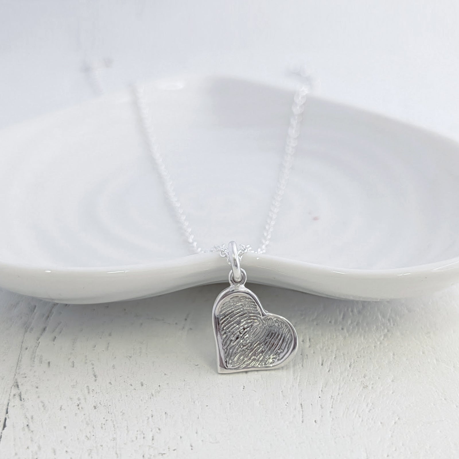 Soft Heart Fingerprint Charm handcrafted in sterling silver or solid gold. Personalised with a real fingerprint and framed within a softly sculpted heart, creating a meaningful keepsake jewellery gift.