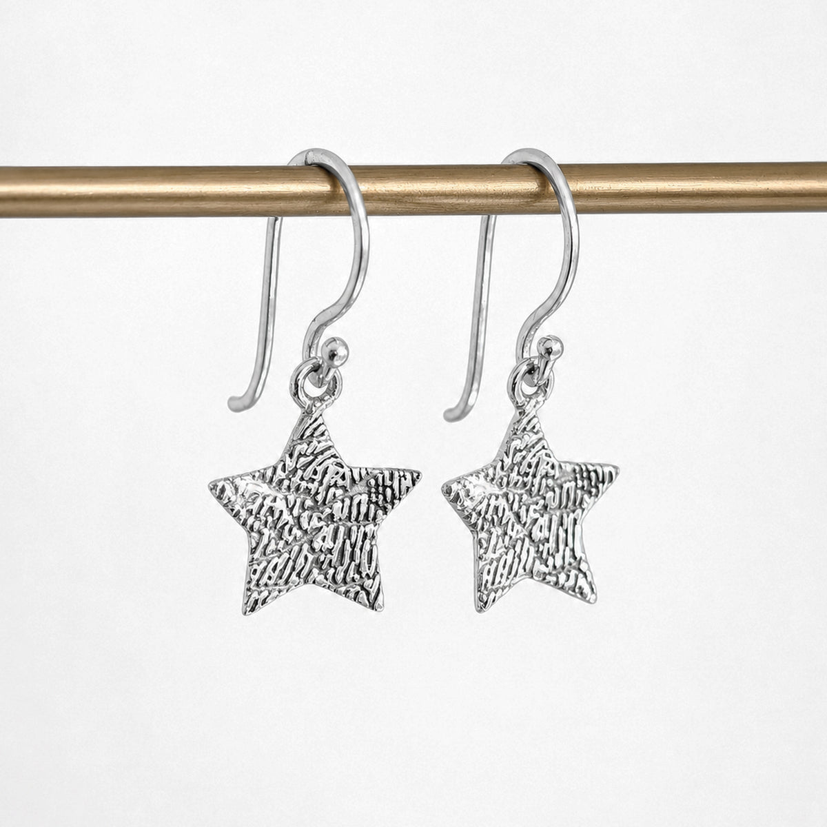 Personalised Fingerprint Star Earrings – Elegant star-shaped dangle earrings featuring your loved one's unique fingerprint engraved in beautiful detail. Available in sterling silver or gold and handcrafted to order.