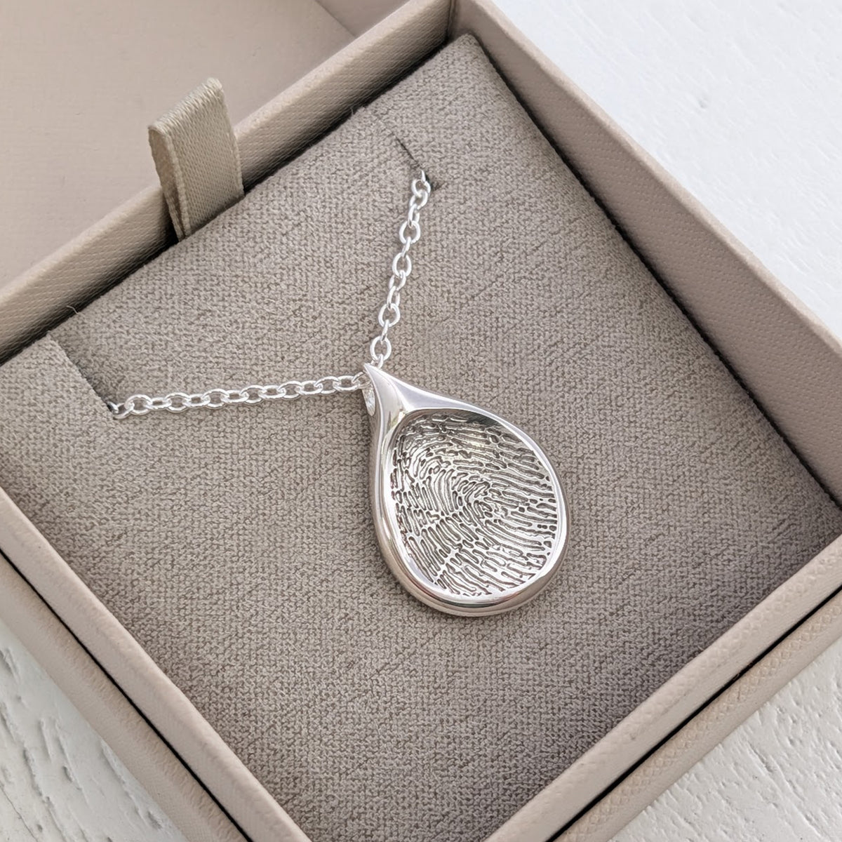 Teardrop Fingerprint Necklace personalised with a real fingerprint and handcrafted in silver or gold. A beautiful memorial jewellery design and sentimental keepsake gift to celebrate a loved one’s memory.