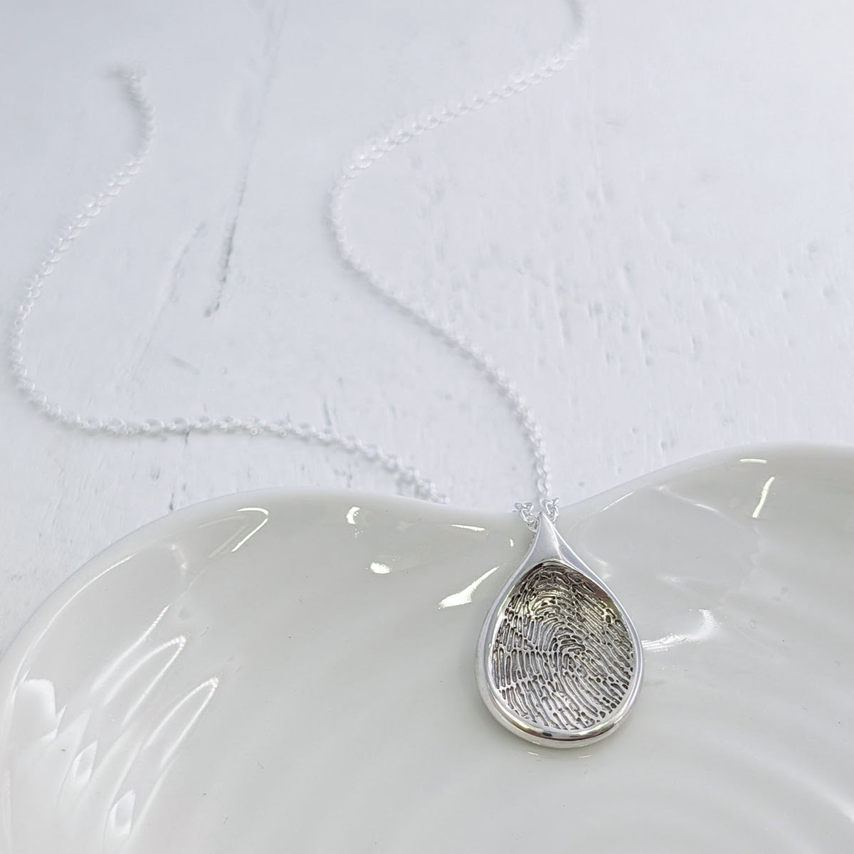 Handmade Droplet Fingerprint Pendant available in sterling silver, 9ct gold or 18ct gold. Individually crafted to order and engraved with a genuine fingerprint, preserving every unique detail in a timeless necklace.