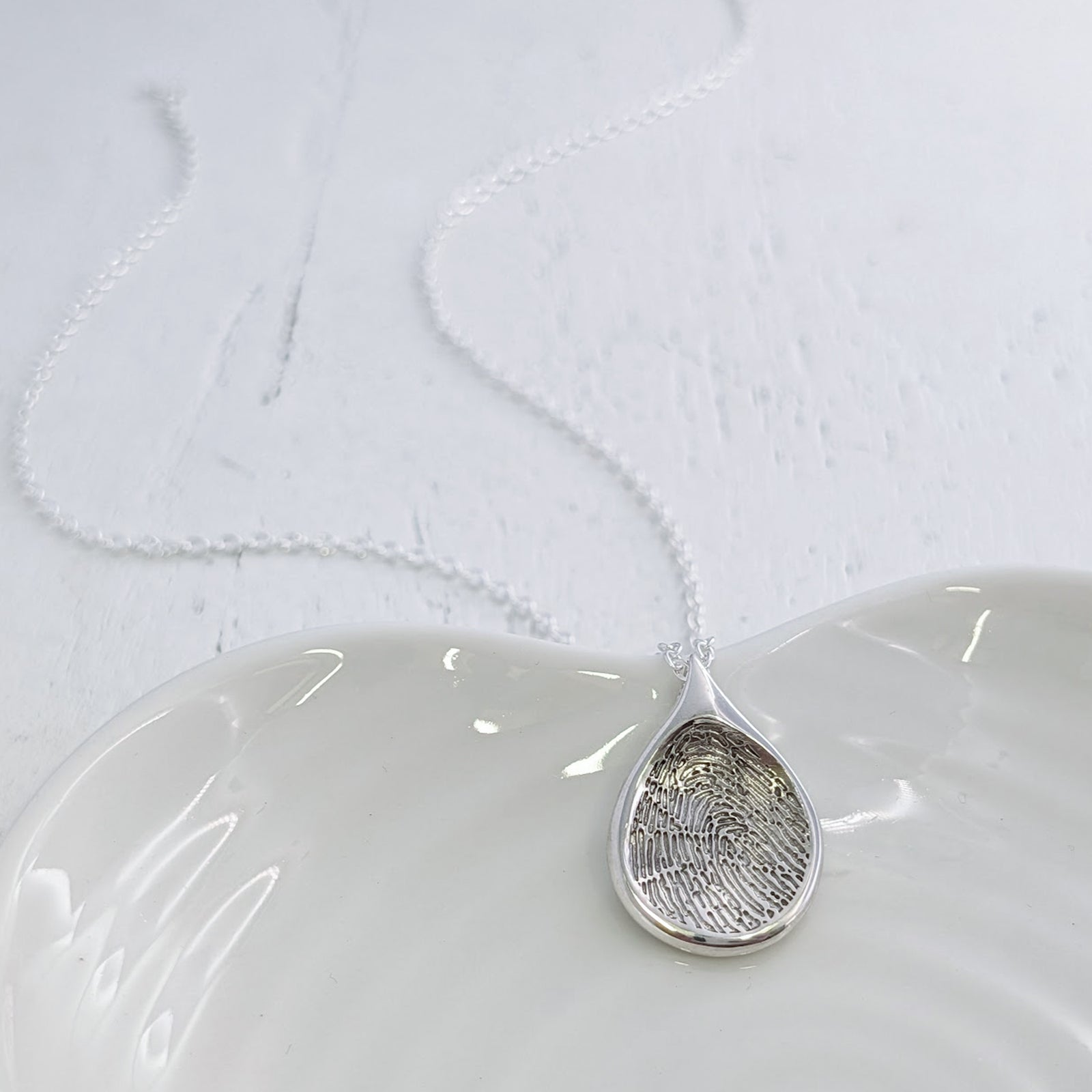 Handmade Droplet Fingerprint Pendant available in sterling silver, 9ct gold or 18ct gold. Individually crafted to order and engraved with a genuine fingerprint, preserving every unique detail in a timeless necklace.