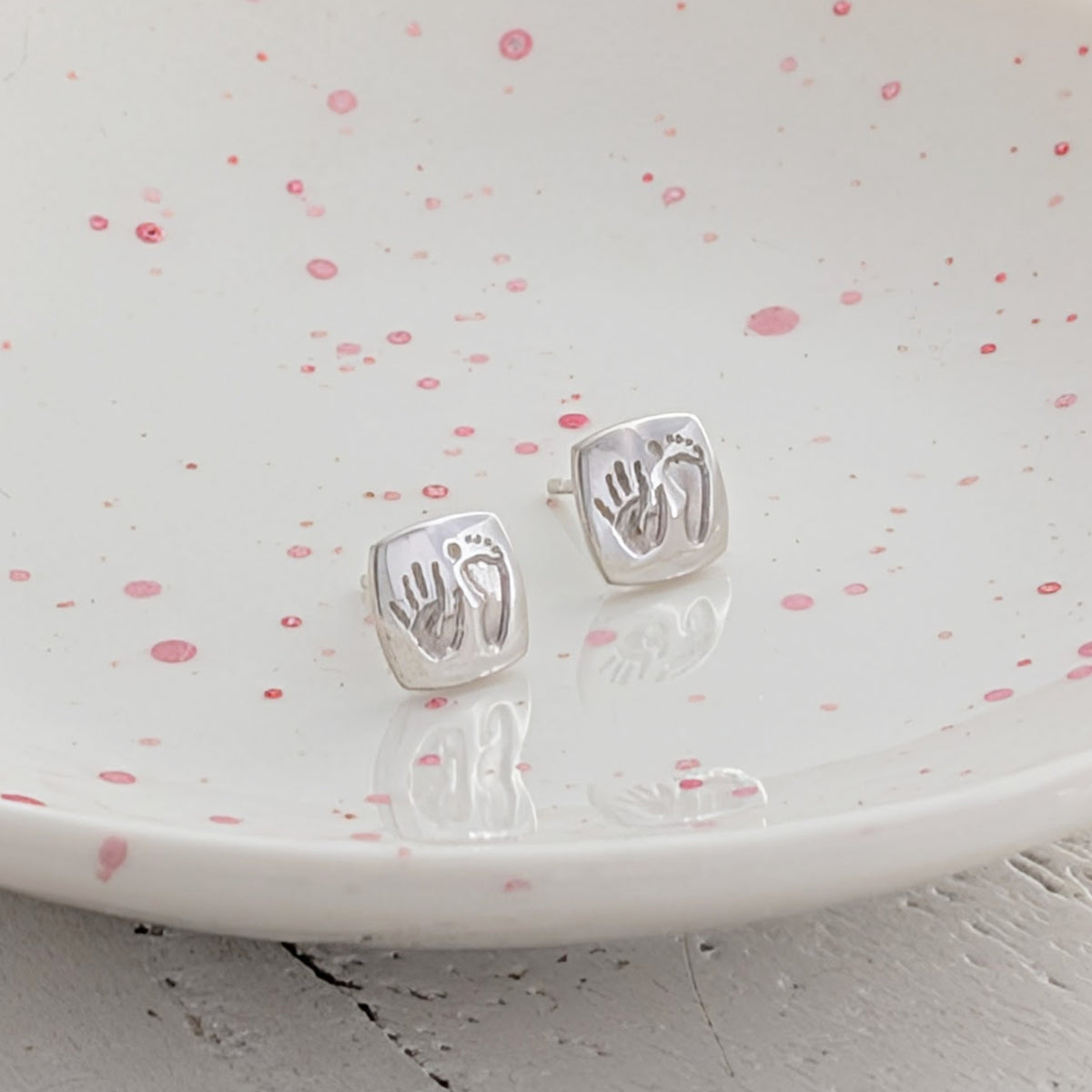 Square cushion handprint and footprint stud earrings, individually handmade in silver or gold and engraved with your child's real prints to create a treasured keepsake.