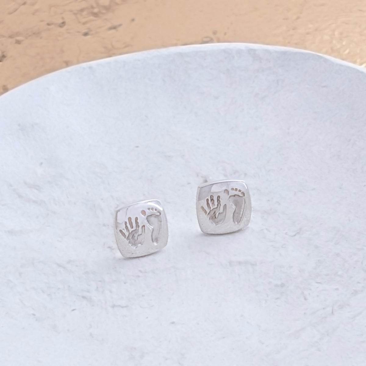 Bespoke handprint and footprint cushion earrings crafted in silver or gold, preserving the precious details of your baby's tiny hands and feet in a timeless design.