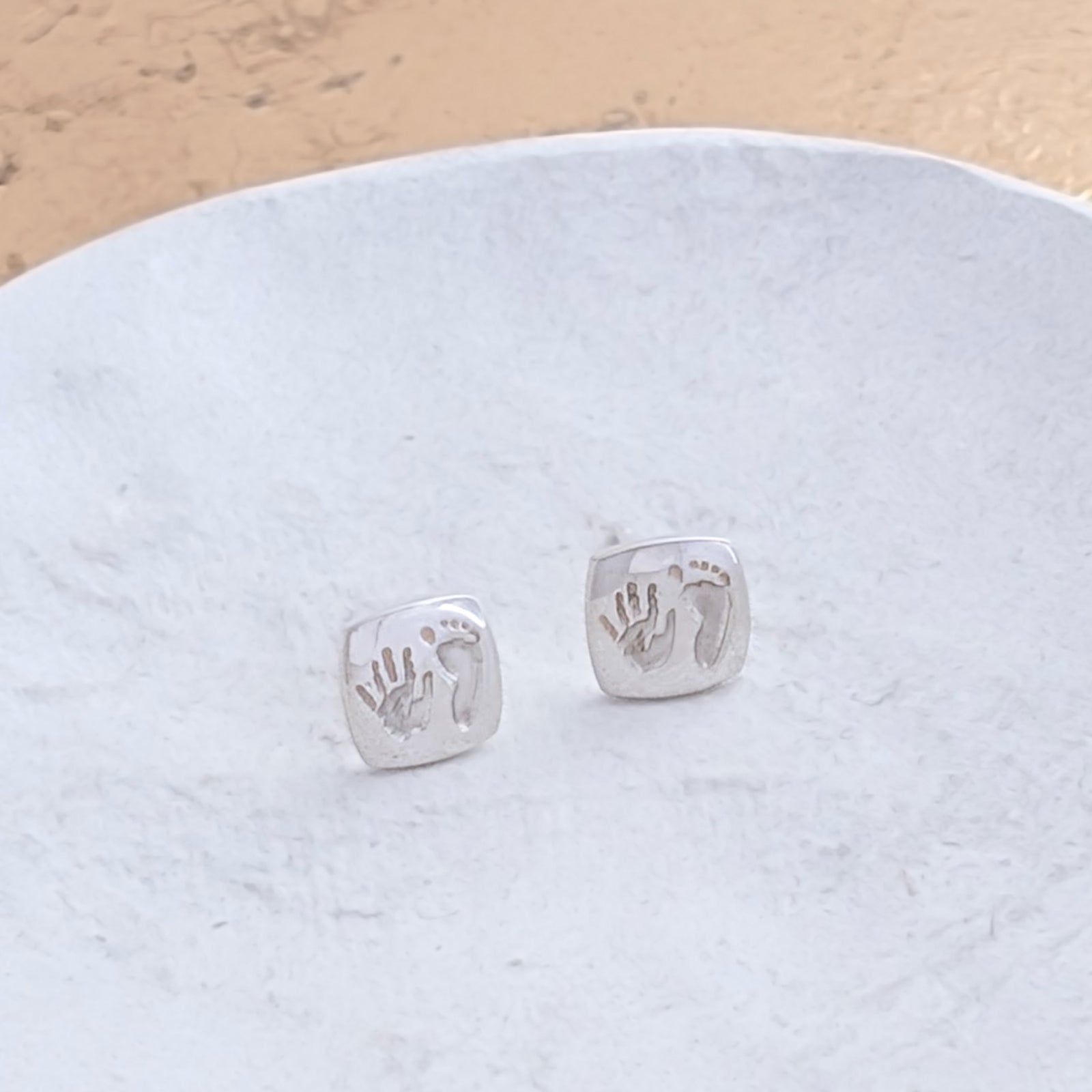 Bespoke handprint and footprint cushion earrings crafted in silver or gold, preserving the precious details of your baby's tiny hands and feet in a timeless design.