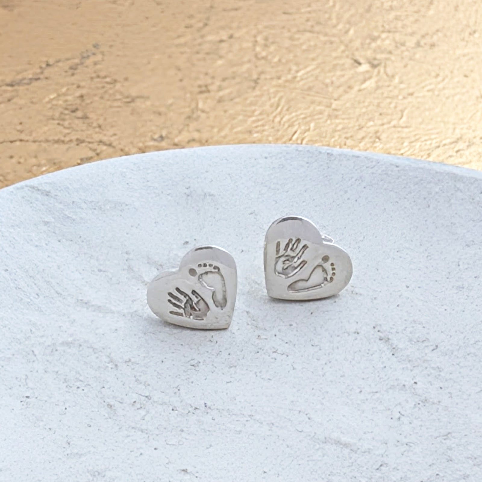 Custom baby handprint and footprint stud earrings in sterling silver. Meaningful memory jewellery designed to celebrate the tiny hands and feet that grow far too quickly.