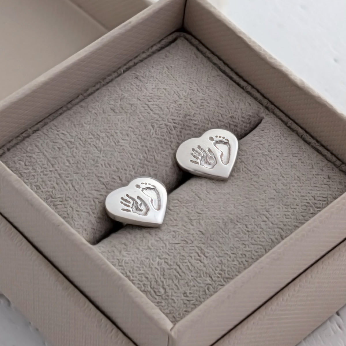 Sterling silver heart stud earrings engraved with your child's handprint and footprint. Handmade keepsake jewellery capturing precious memories of your baby in beautiful detail.