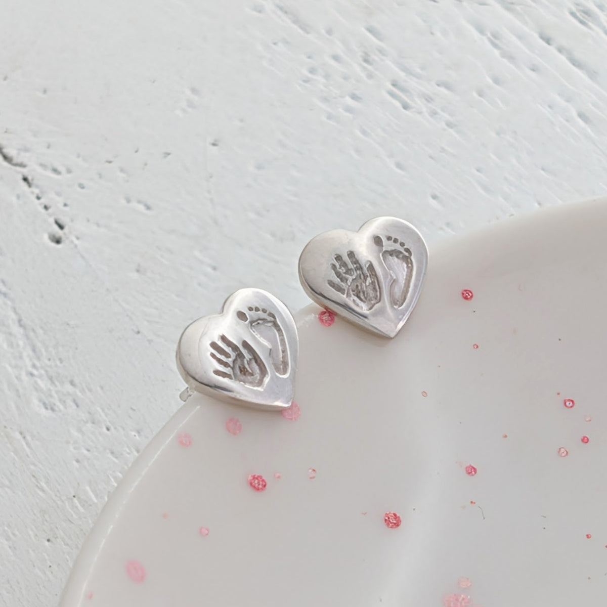 Handmade heart-shaped handprint and footprint earrings personalised with your baby's own prints. A beautiful keepsake gift for mums, new parents, and growing families.