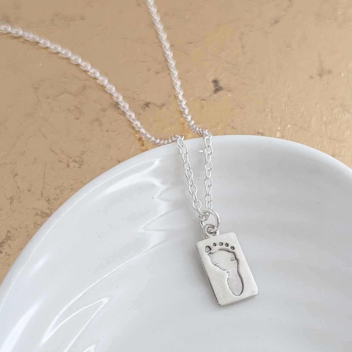 Silver necklace with baby footprint pendant. Baby Handprint Keepsake Jewellery UK