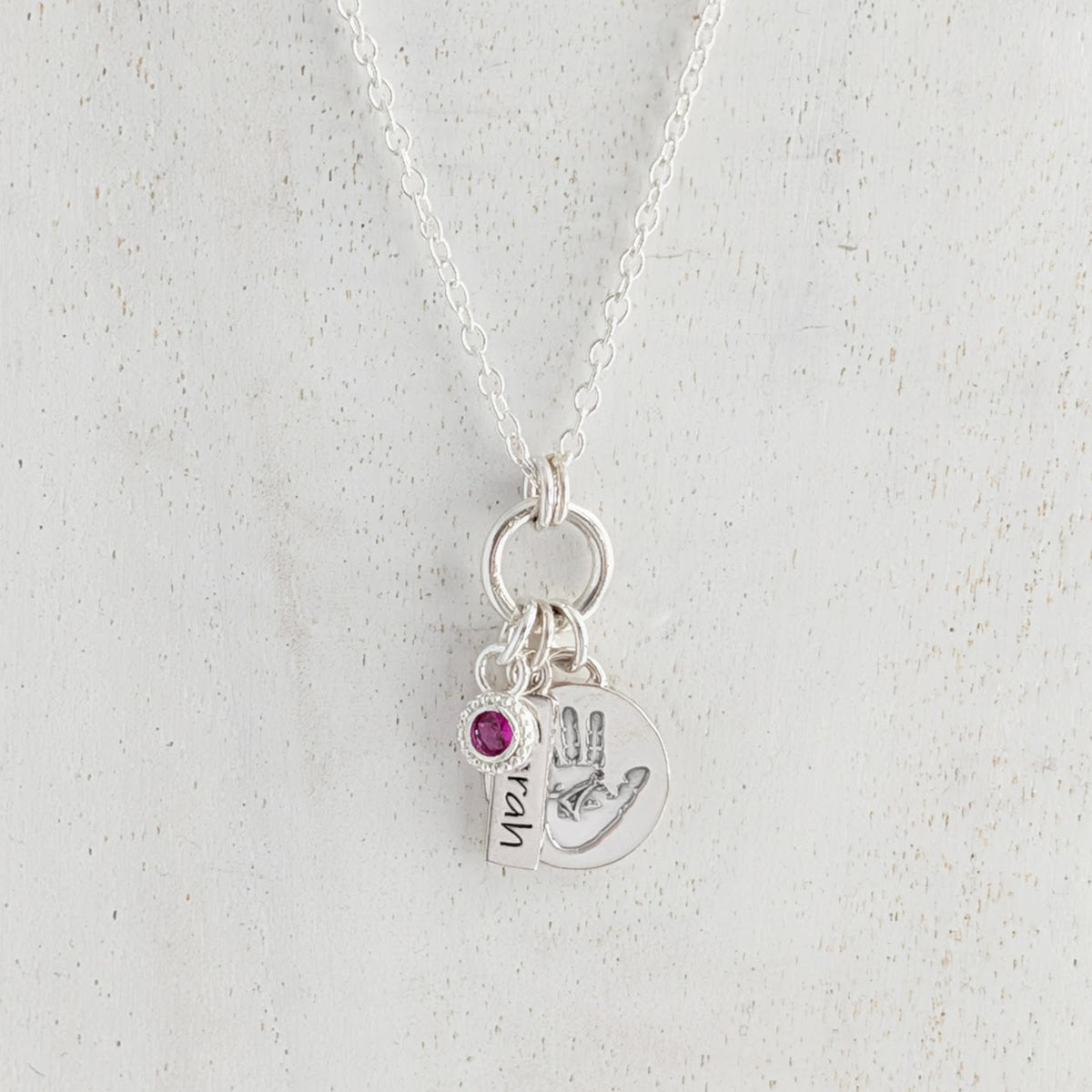 Personalised disc silver necklace engraved with child's own handprint or footprint and birthstone.