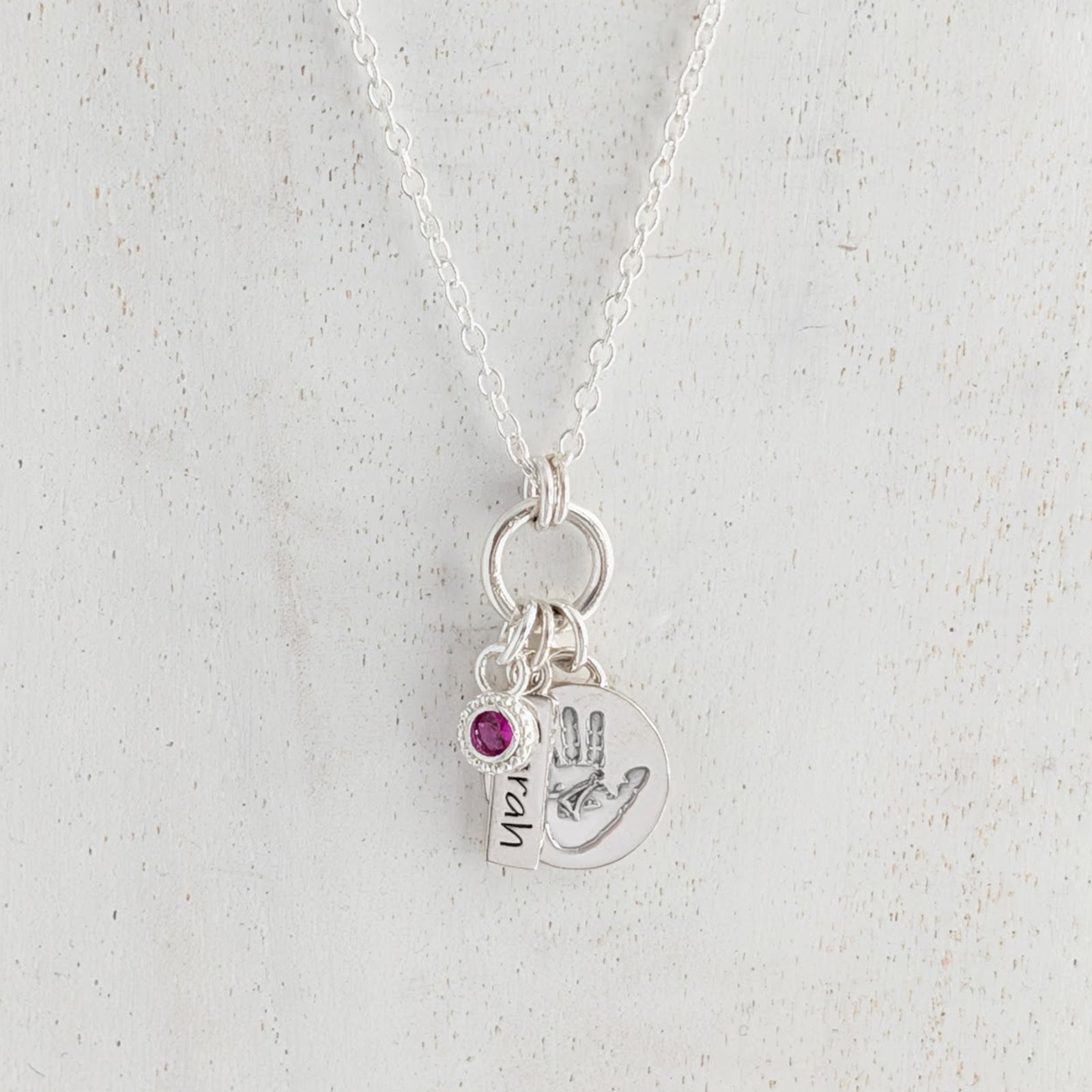 Personalised disc silver necklace engraved with child's own handprint or footprint and birthstone.