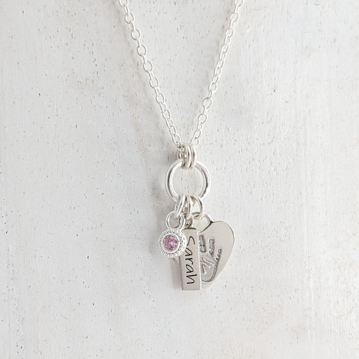 Personalised heart silver necklace engraved with child's own handprint or footprint and birthstone.