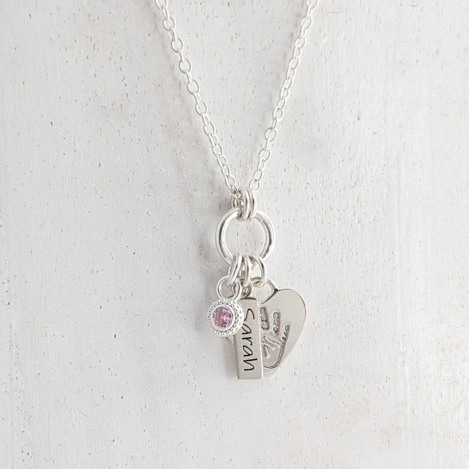 Personalised heart silver necklace engraved with child's own handprint or footprint and birthstone.