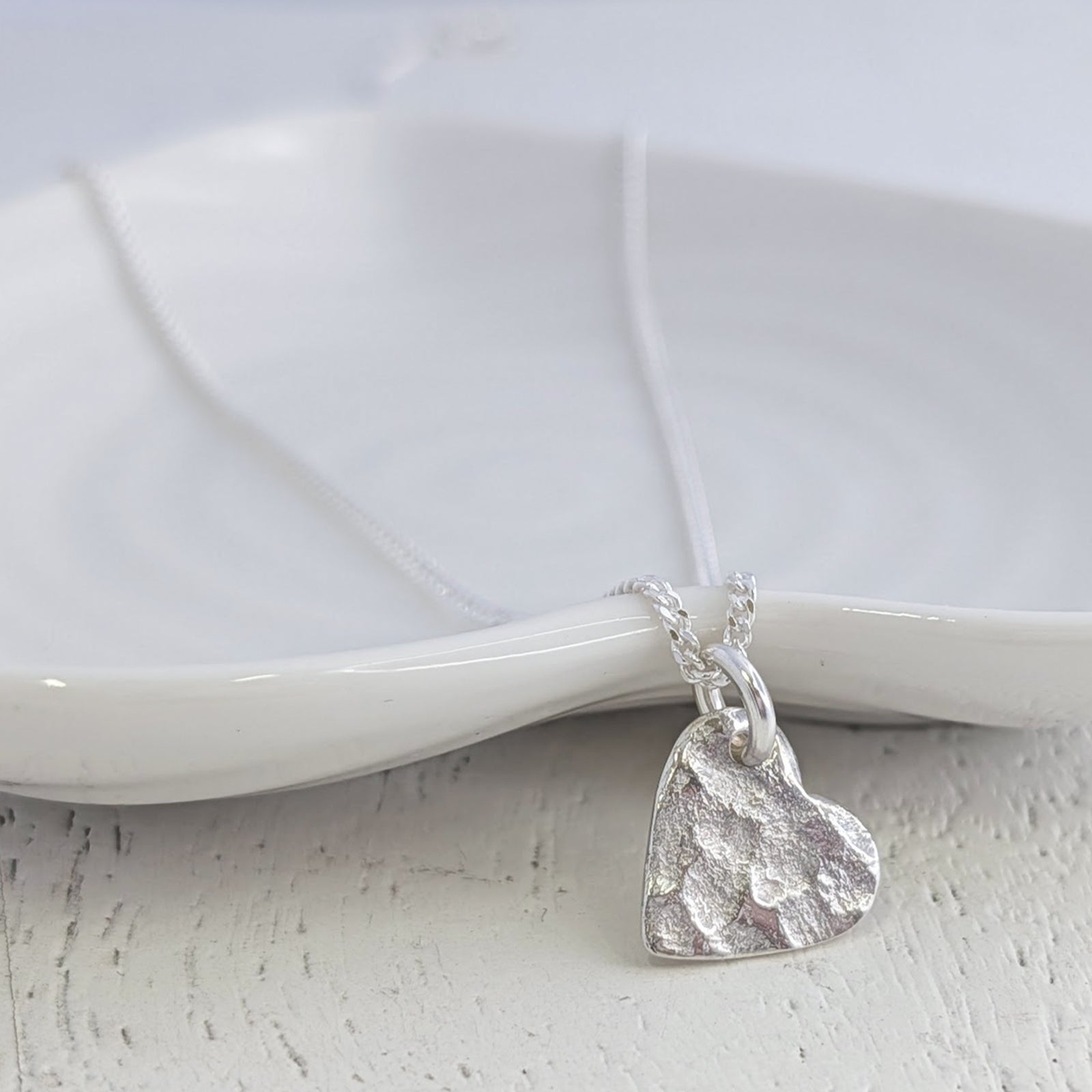 Sterling silver memorial ashes heart necklace handcrafted with the impression of cremation ashes, creating a beautifully textured keepsake to honour a loved one.