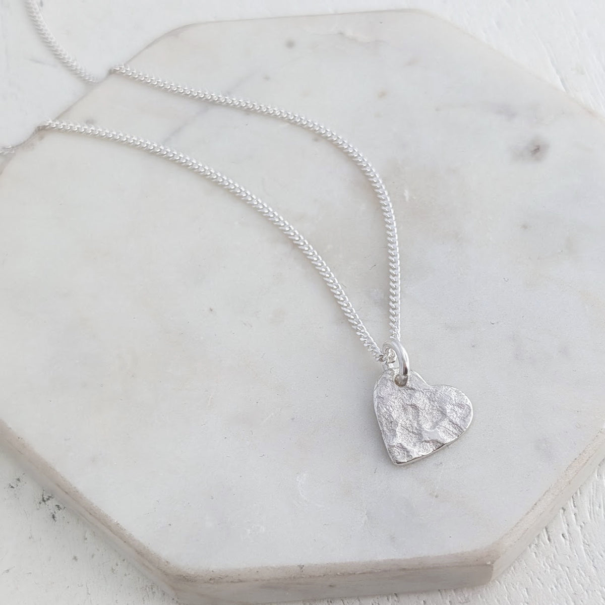 Remembrance heart necklace crafted from sterling silver and imprinted with a loved one's ashes, creating a subtle and meaningful memorial jewellery design.