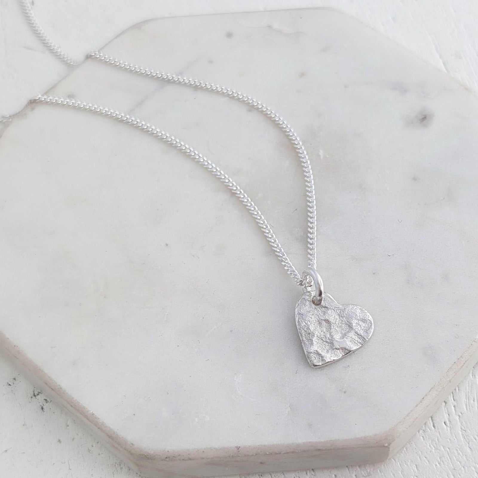 Remembrance heart necklace crafted from sterling silver and imprinted with a loved one's ashes, creating a subtle and meaningful memorial jewellery design.