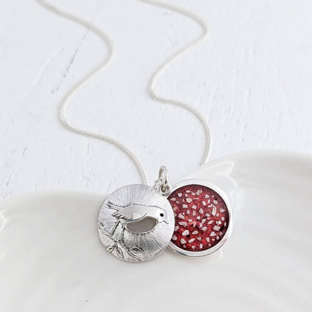 Memorial Locket engraved with a robin and featuring cremation ashes