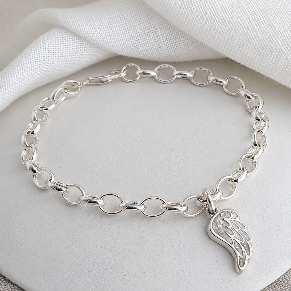 silver charm bracelel with handmade angel wing charm holding memorial cremation ashes