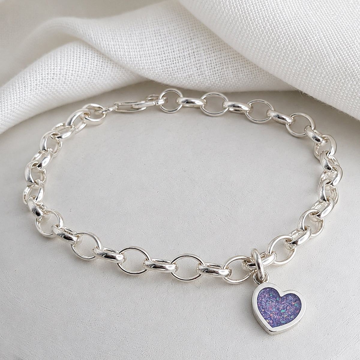 silver charm bracelel with handmade heart charm holding memorial cremation ashes