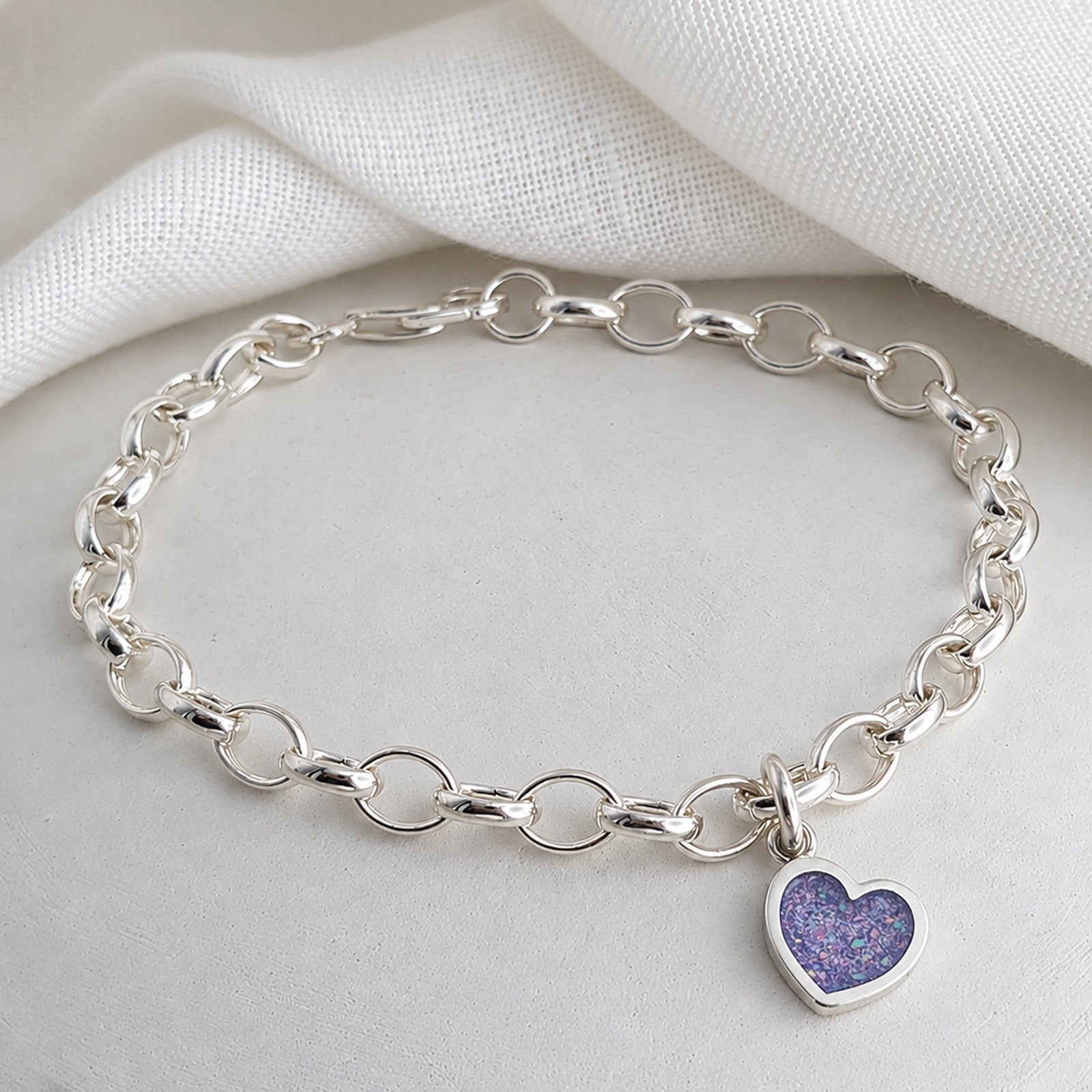silver charm bracelel with handmade heart charm holding memorial cremation ashes