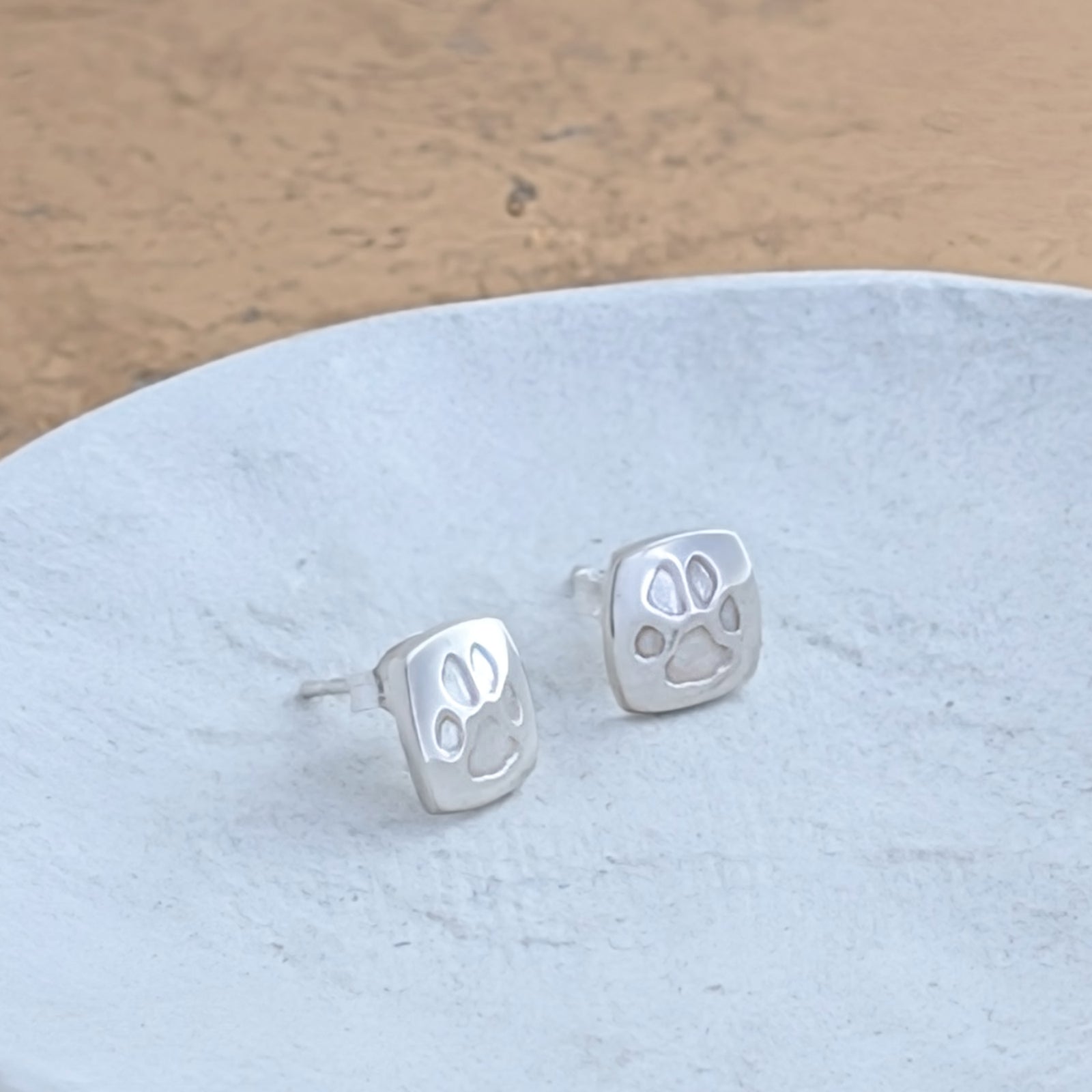 Sterling silver pawprint cushion stud earrings personalised with your pet's unique paw print. Handmade pet memorial jewellery designed to celebrate the bond shared with a beloved dog or cat.