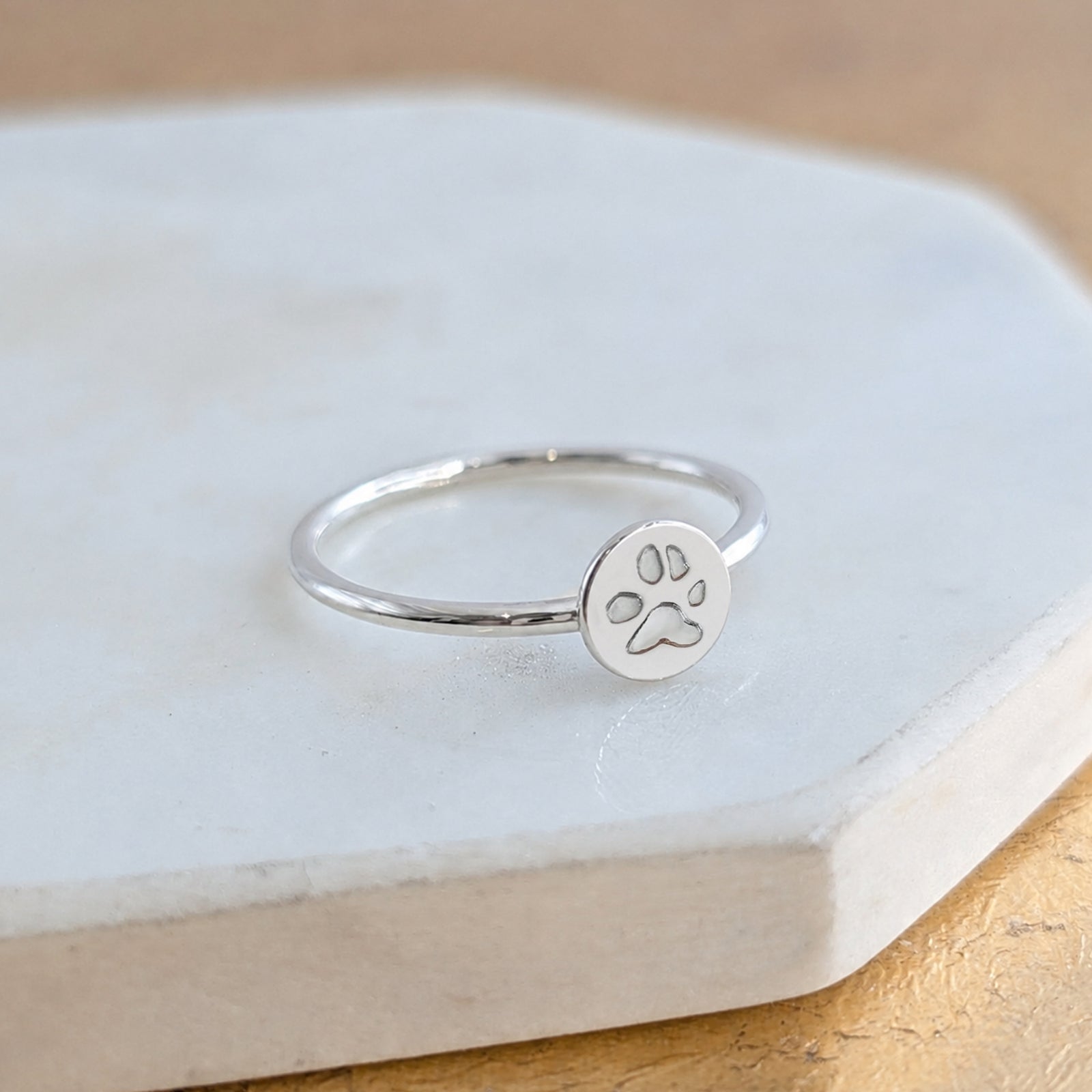 Sterling silver paw print ring handmade in the UK, personalised pet memorial jewellery featuring a delicate engraved pawprint disc