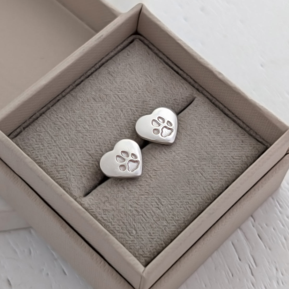 sterling silver pawprint heart stud earrings, handcrafted with your pet's own paw print. Meaningful pet memorial jewellery designed to keep a beloved dog or cat close every day.
